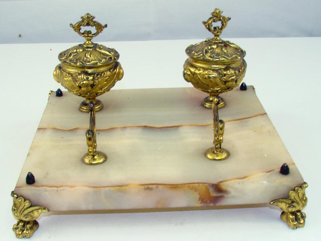 BRASS & ONYX INKWELL / STANDISH: White onyx or alabaster platform fitted with brass lion's paw feet, pen holder, and two hinged-lid inkwells; inkwells have glass inserts; inkwells have putti ornamentation; brass fittings are loose; 9