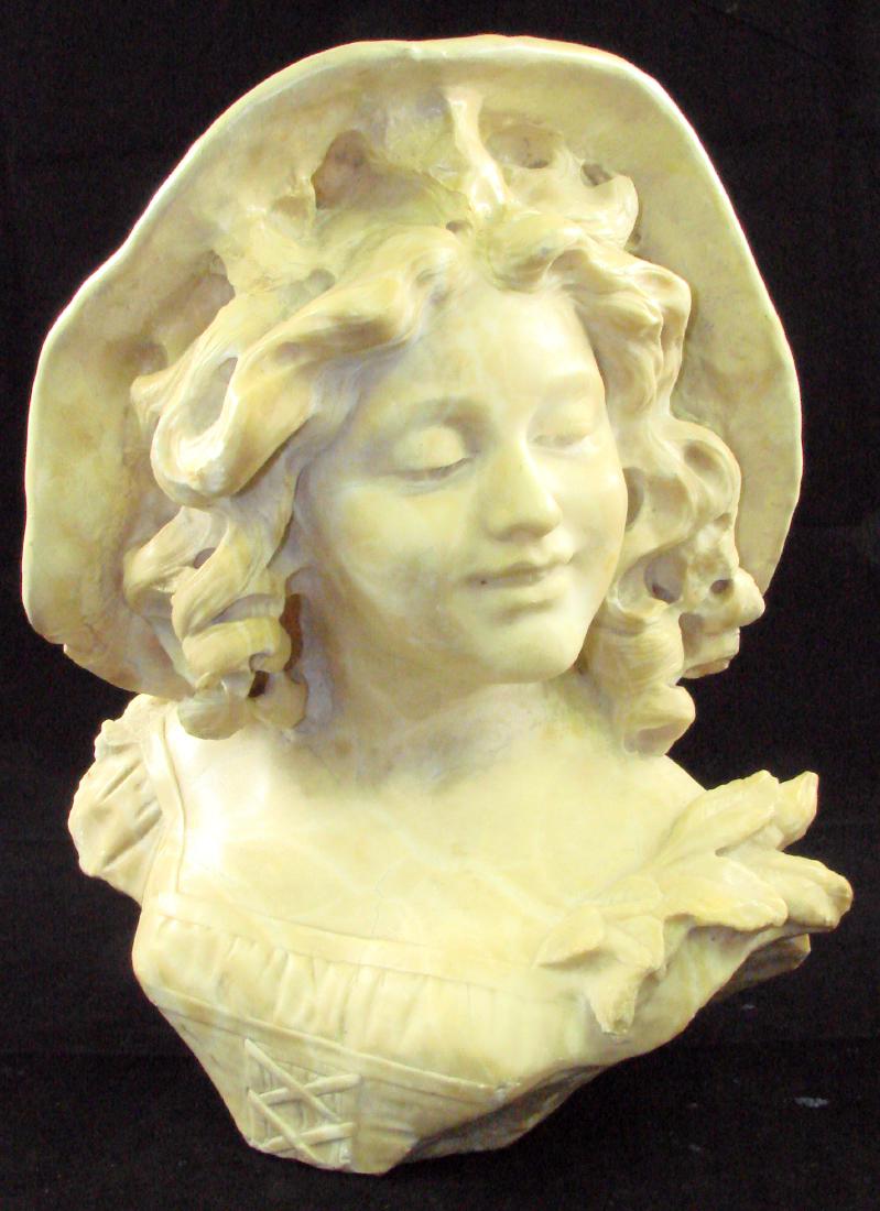 ART NOUVEAU CARVED BUST OF YOUNG GIRL: Carved stone bust of smiling girl with ringlets, possibly marble or alabaster; extensive professional restoration to brim of hat, extending into hair; repair is visible but forgivable; some minor chip