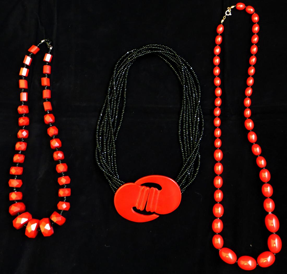 (3) VINTAGE PLASTIC / BAKELITE NECKLACES: Includes: (1) black multi-strand seed bead necklace with large red Bakelite clasp, L-17"; (1) red bead necklace, each oval bead separated with a black seed bead, L-24"; (1) red bakelite faceted bead n