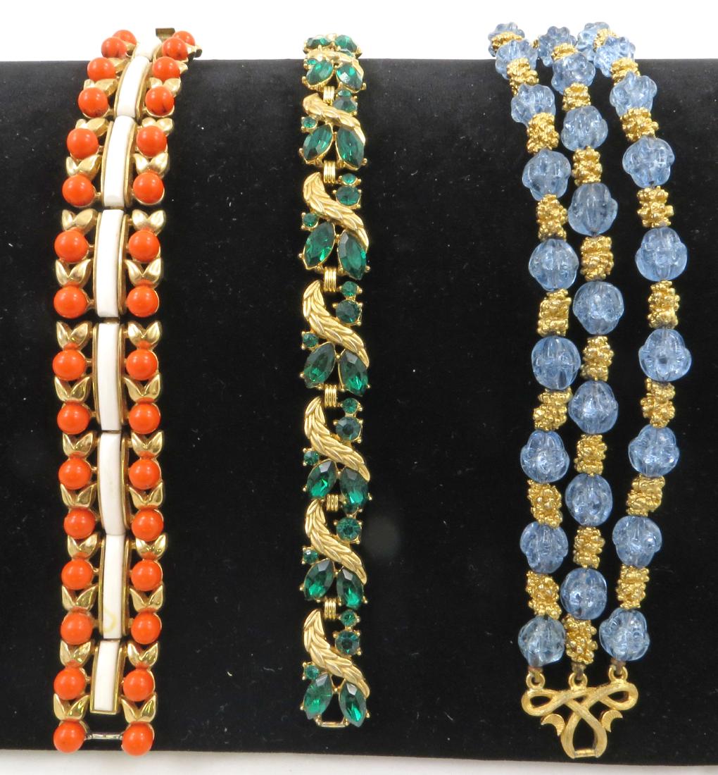 (3) TRIFARI BRACELETS: (1) goldtone with green rhinestones; (1) triple-strand goldtone with light bluel glass beads; (1) goldtone with orange and white plastic inset beads, yellow stain on one white inset and some orange ba