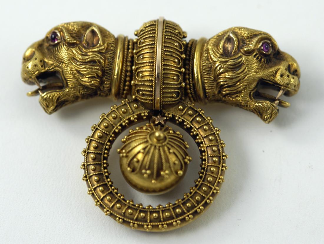 ANTIQUE GOLD ETRUSCAN REVIVAL BROOCH: Unsigned, unmarked, double headed lions with exposed tongues, red stone eyes, intricate detail, bead and thread motif; slight dent/damage to underside of hoop, visible from the back of the pin; L-1 3/