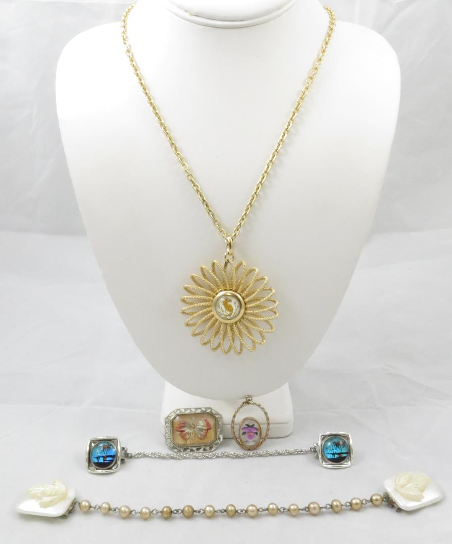 (5) PCS. COSTUME JEWELRY with LUCITE/PLASTIC ELEMENTS: (1) sweater clip / chain with butterfly wing scenic panels, silvertone; (1) faux mother of pearl sweater clip and chain; (1) pendant with carved and painted lucite medallion, orchid motif; (1) brooch 
