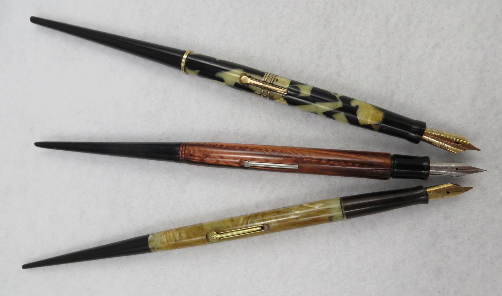 (3) VINTAGE DESK PENS: All lever fill; (1) Waterman Patrician desk pen, cream marbelized pearl with Waterman's Ideal nib; chip out of plastic surrounding nib; restored; (1) Esterbrook desk pen with copper pearlized barrel a
