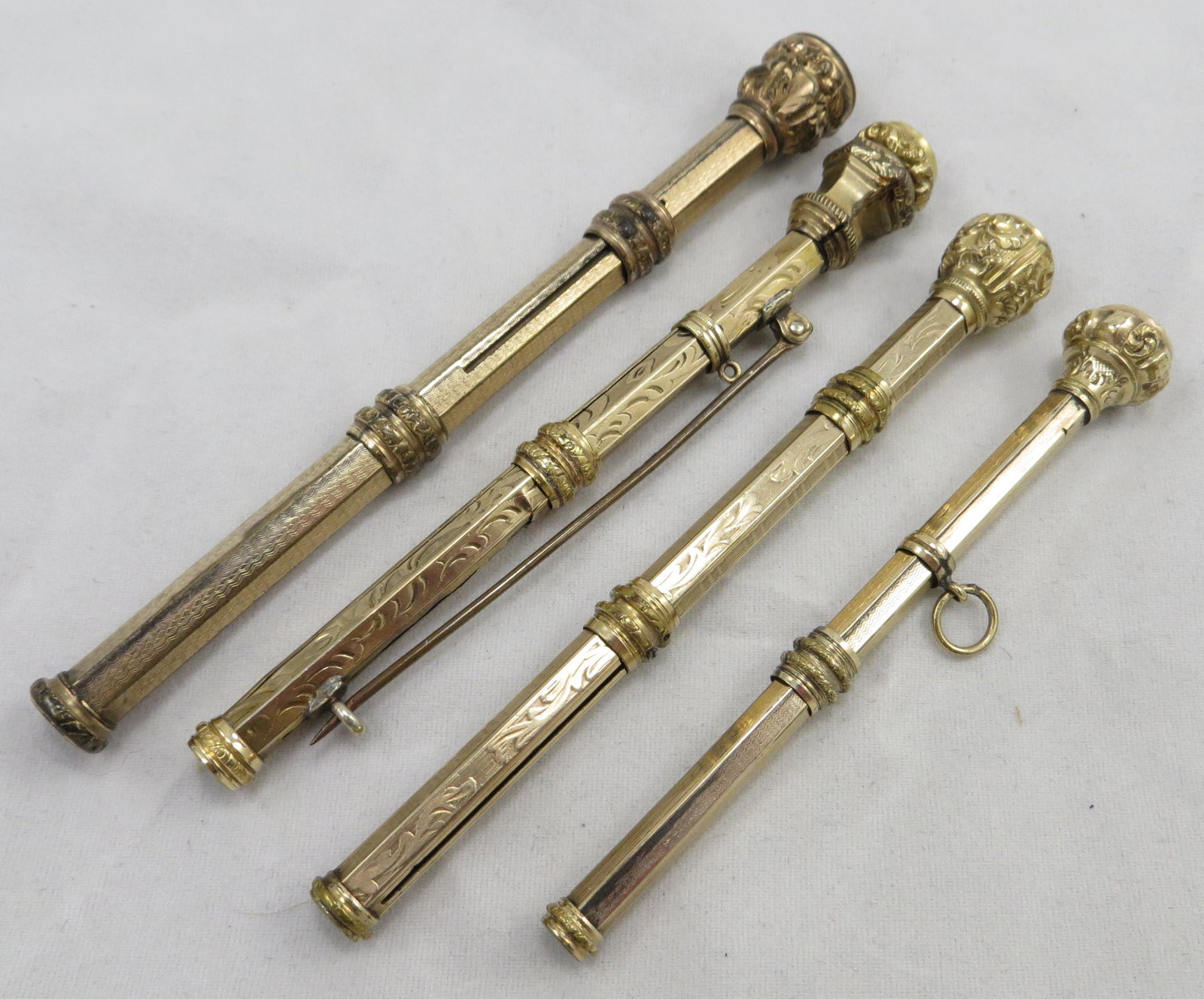 (4) LADIES VICTORIAN JEWEL-TOP PENS/PENCILS: Each with slide mechanism, chatelaine/wearable writing instruments; (1) red jeweled top, engraved shaft, mechanical pencil has been turned into a pin, mechanism not working; (1) mechanical pencil, amb