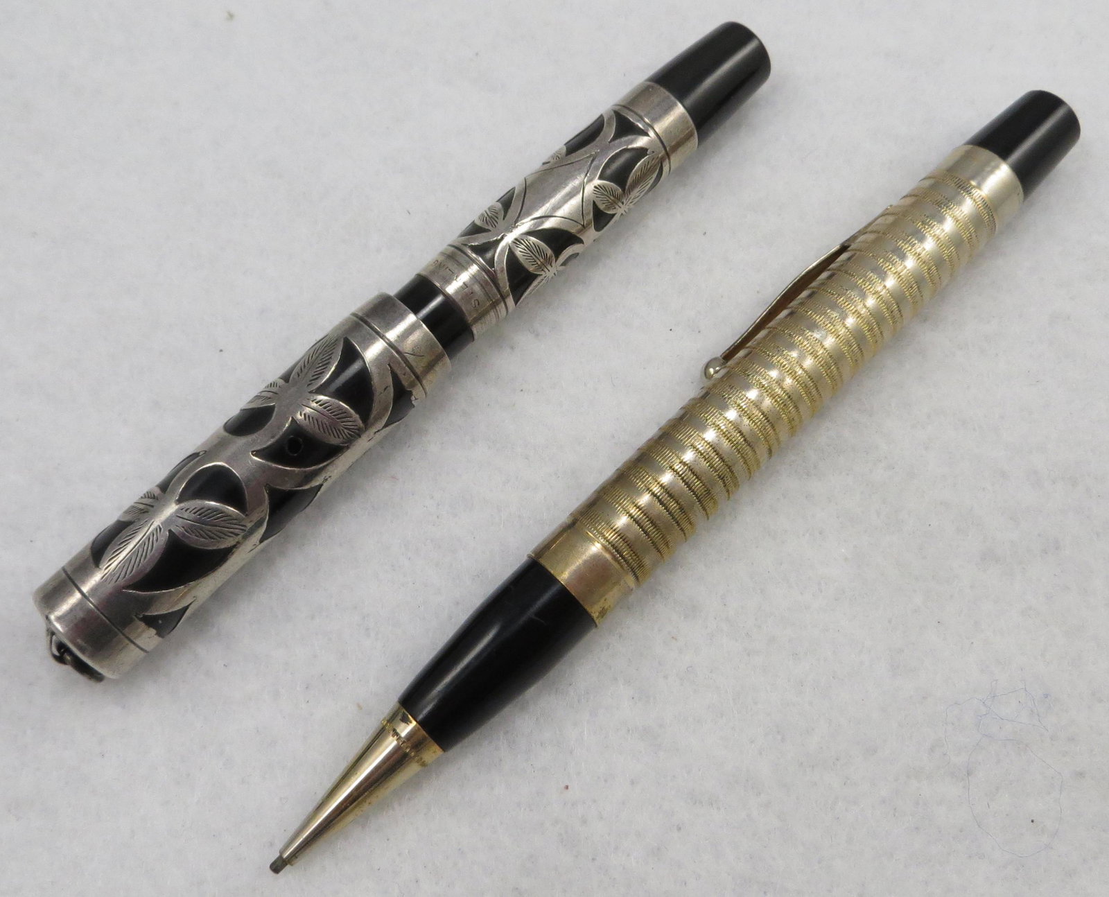 MORRISON'S PENCIL & FOUNTAIN PEN: (1) Morrison's vest pocket fountain pen, sterling silver overlay with leaf design; lever fill with "LM" in wreath cap; 14K Morrison nib, ring top; L-3 7/8"; (1) Morrison mechanical pencil, gold filled