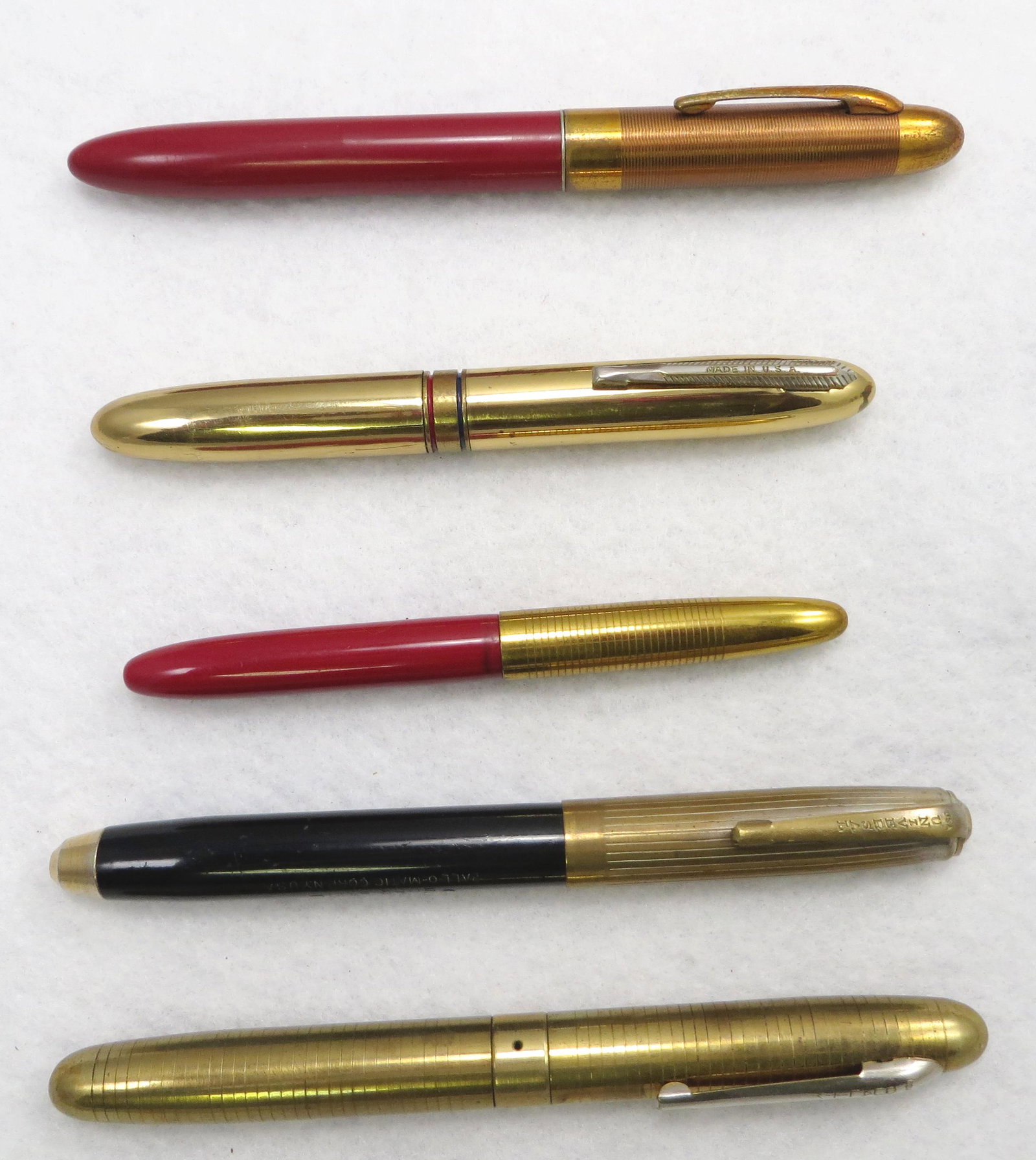 (5) MOSTLY BALLPOINT PENS: WATERMAN, DUAL PENS, ETC.: Includes: (1) satin brass "Quality" dual sided pen; (1) shiny brass dual sided pen; (1) Waterman red barrel, brass cap pen; (1) Universal Buck Ball pen, with brass cap; (1) Sheaffer Fineline lever fil