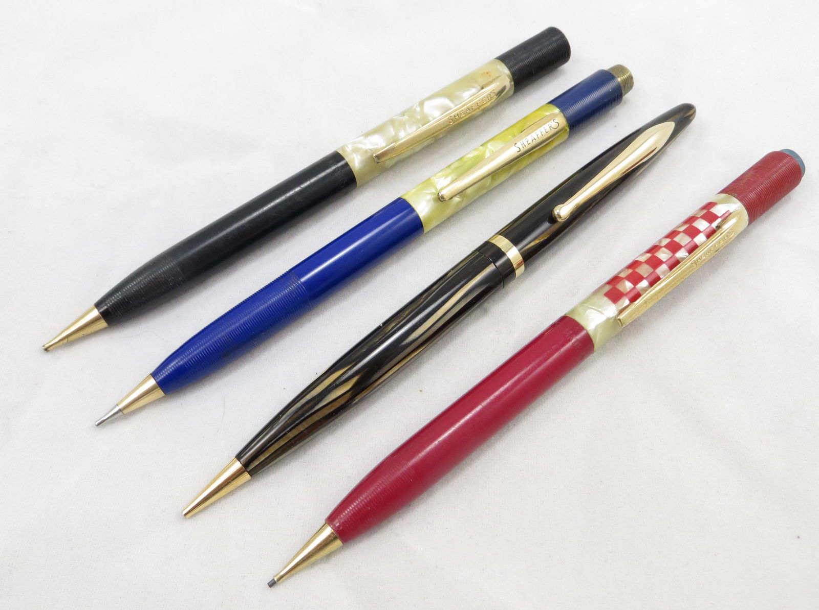 (4) VINTAGE SHEAFFER MECHANICAL PENCILS, ADVERTISING,: Includes: (1) Sheaffer's 400 mechanical pencil, ebony & pearlized vertical stripes; (1) black and pearlized pencil with horizontal ribs, no eraser cap; needs cleaning; (1) blue and pearlized pencil wi