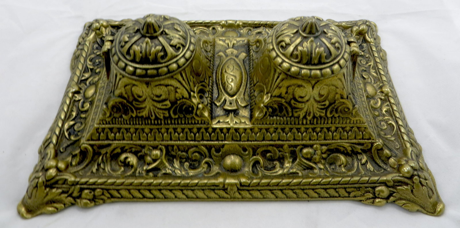 RENAISSANCE REVIVAL CAST BRASS INKSTAND: Footed, heavy cast brass base with two hinged lid inkwells, each with porcelain inserts; acanthus leaf and horn of plenty motif; some ink residue along lower border (should clean); base: 10 1/2" x 6 3