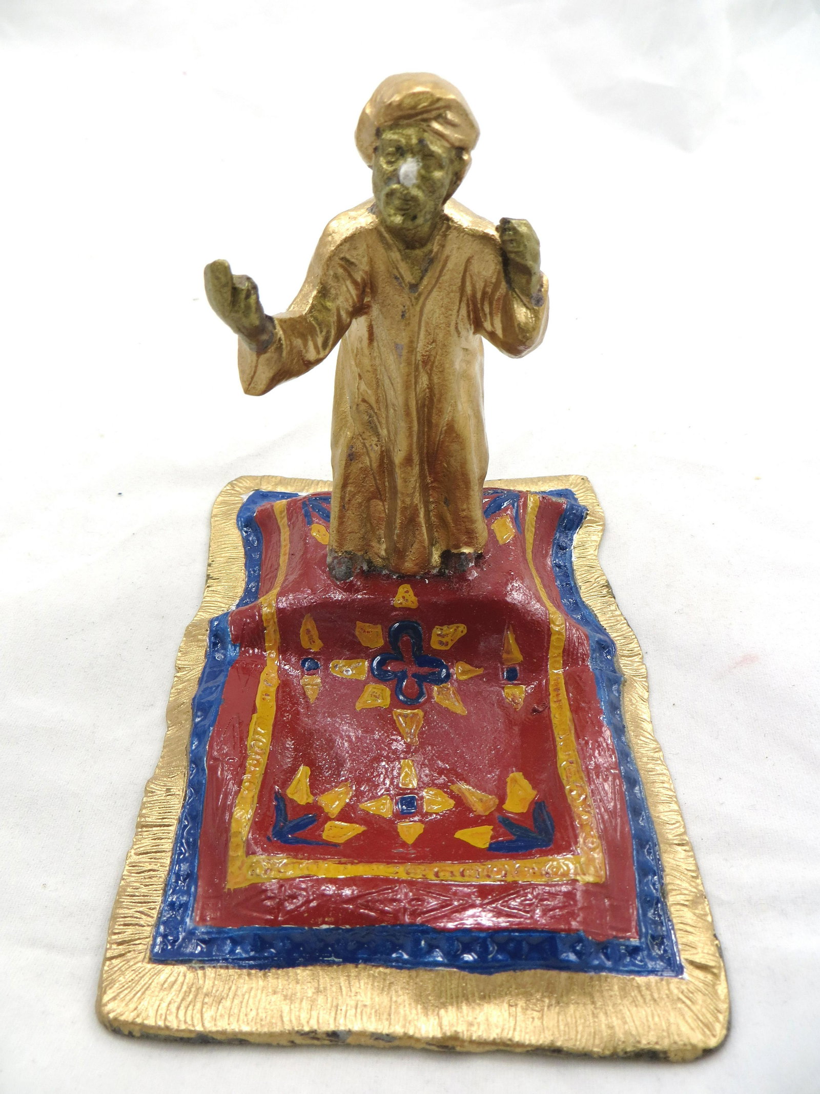 AUSTRIAN ARAB PEN HOLDER: Man stands on carpet; painted metal; bottom reads: "Trademark Coronet Registered Austria" with a crown symbol; nibbed pen used as a prop; very minor paint loss; L-5", VG-EX