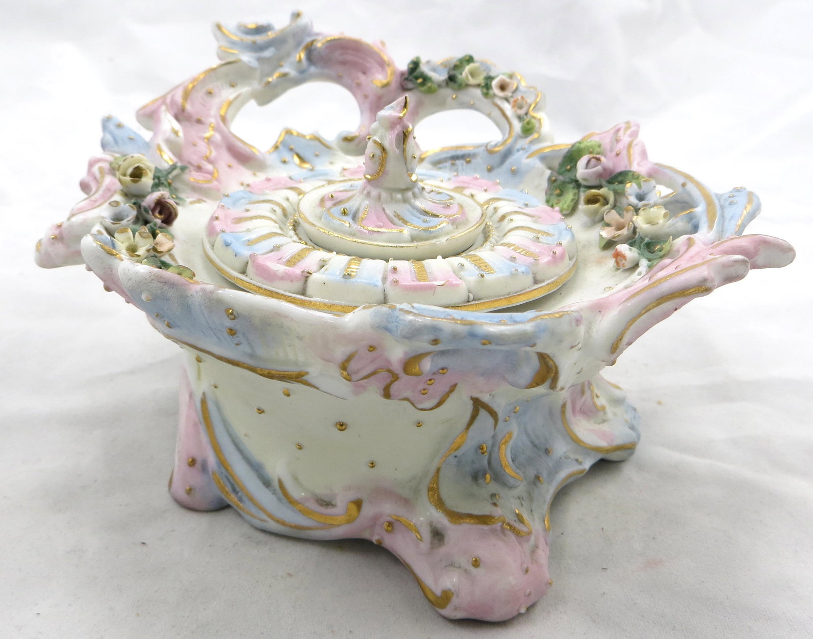 GERMAN BISQUE INKWELL: Late 1800's; soft polychrome with open work and applied florals; inkwell has decorated lid and insert; minor gilt rubbing, flea bite on insert; L-5 1/2", VG-EX
