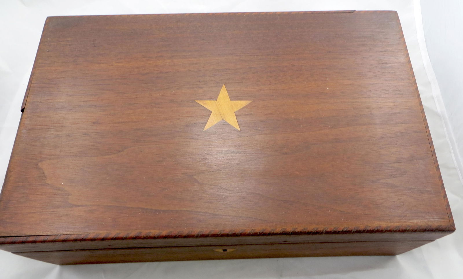 INLAID WALNUT LAP DESK: Likely New England; inlaid star on top and inlaid shield at keyhole; working key; top left edge has a 4 1/2" long piece of molding missing; interior has original velvet lining; very worn and stained;