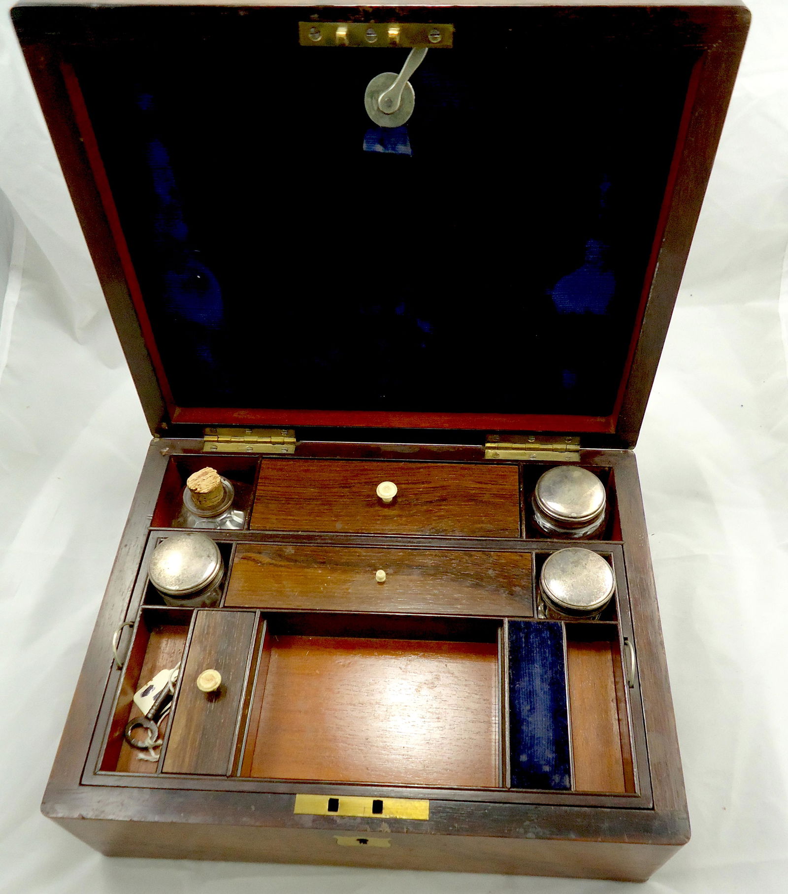 WALNUT LAP DESK with BRASS SHIELD INSERTS: Exterior has minor scratches; interior is in very good condition: contains original jars and bottles, removable tray, navy blue velvet is in very good condition; interior folder for letters; (1) inter