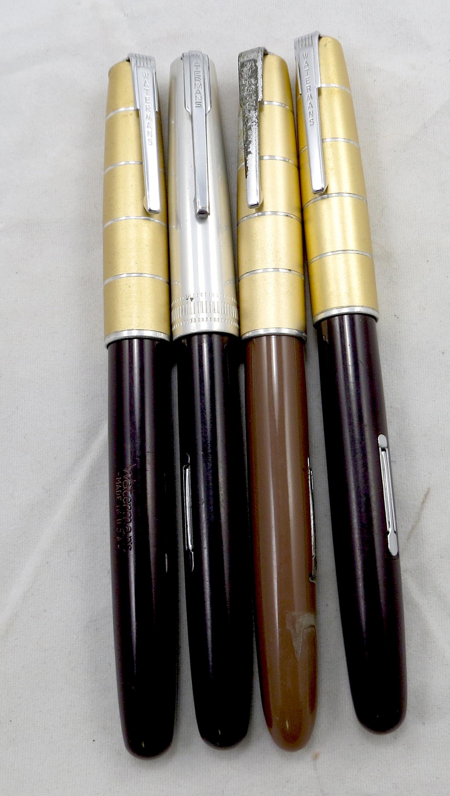 (4) WATERMANS FOUNTAIN PENS: USA; (1) black barrel, gold tone lid, 14K Ideal nib; (1) black barrel, gold tone lid, 14K Ideal Account nib; (1) black barrel, silvertone lid, unmarked nib; (1) light brown barrel, damaged - internal