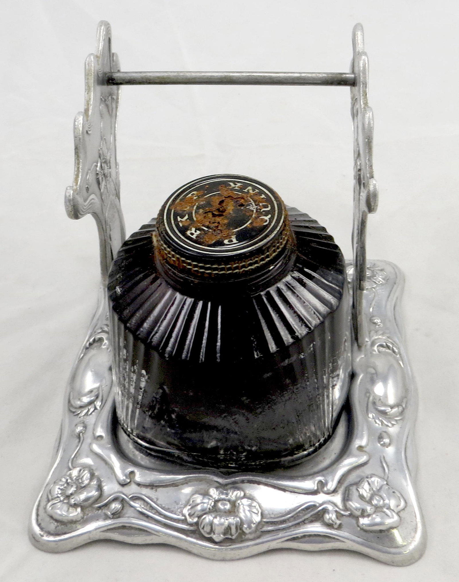 ART NOUVEAU INKWELL STAND: Metal with relief floral design; (3) pen holder, along with Parker Black Quink (dried up); lid rusting; base of stand does not sit perfectly flat; L-4 1/4", G-VG