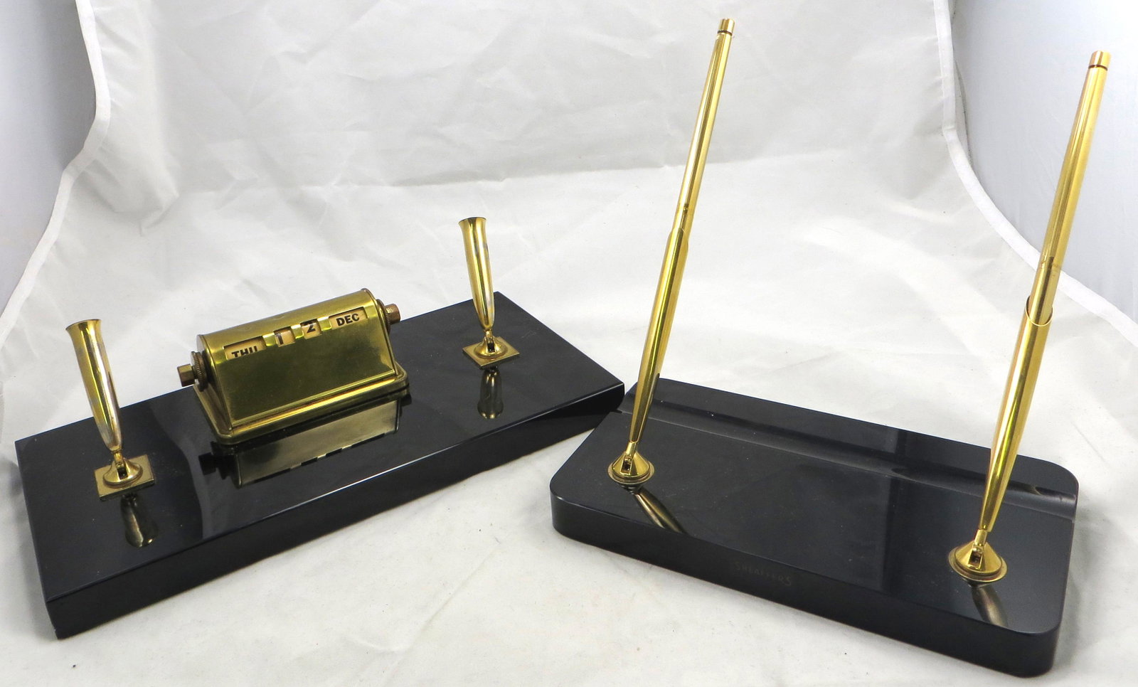 (1) SHEAFFER DESK SETS: Black onyx bases; (1) double with original pen & pencil; (1) includes calendar, has a few minor dents on top; gold finish has rubbing on pen/pencil holders; longest L-10", G-VG