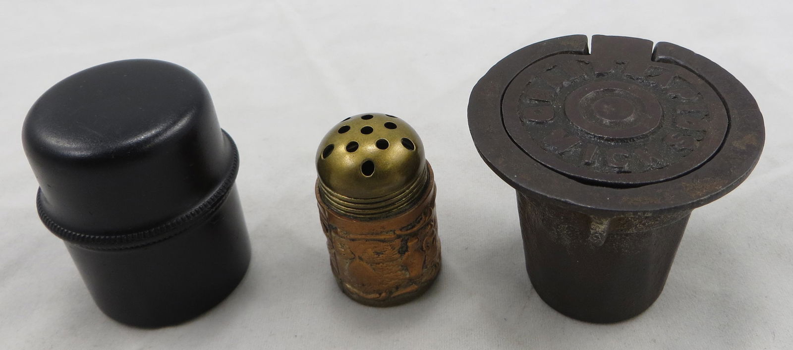 (2) ANTIQUE INKWELLS & SANDER: Includes: (1) sander / shaker, embossed scene with windmill; H-1 1/4"; (1) gutta percha traveler inkwell: cylidrical with interior and exterior screw lids; H-1 5/8"; (1) cast iron school desk inkwell: