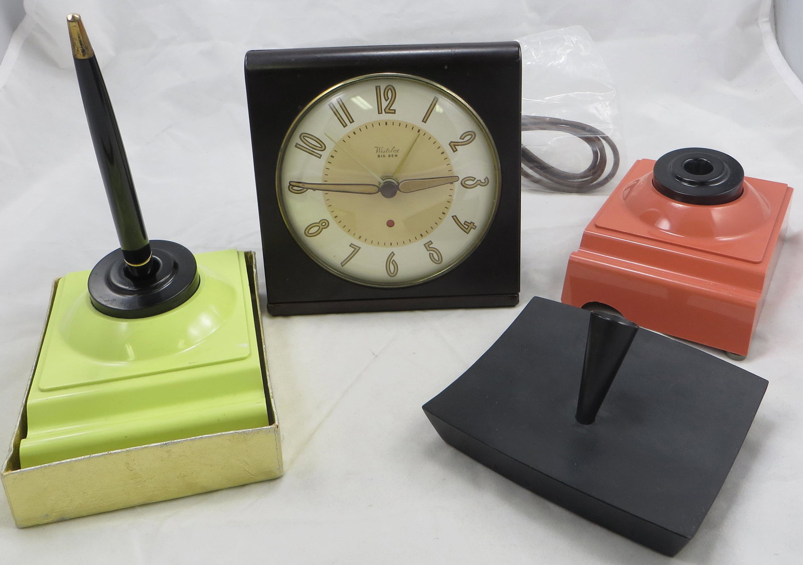 (4) VINTAGE DESK ITEMS: (1) Parker pen holder: simulated slate; (1) bakelite Westclox Big Ben desk clock, electric; (2) plastic Madisons desk sets - 1- has pen and certificate, both with original labels; peach one has large 