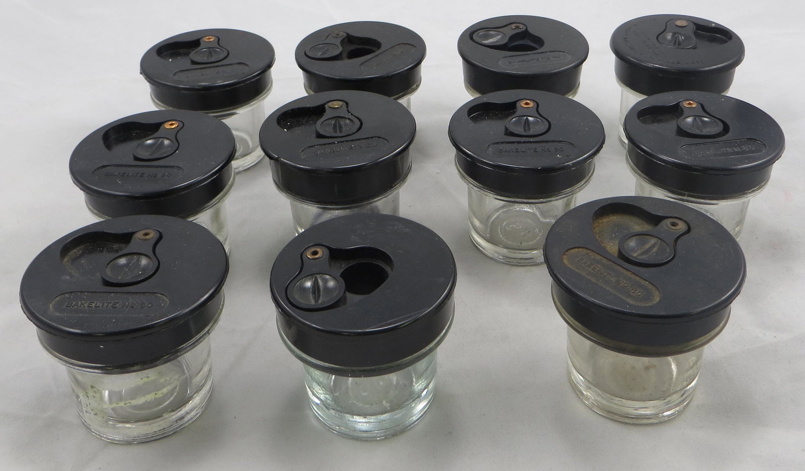 (11) SCHOOL DESK INKWELLS: (9) Bakelite, No. 60 lids; (1) The Fanevil - Kenney Bros. Inc, Baldwinville Mass.; (1) plain; H-1 3/4", VG-EX