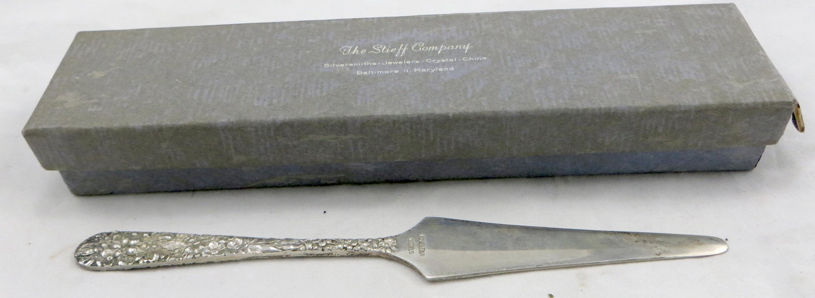 STIEFF STERLING REPOUSSE LETTER OPENER: Stieff "Rose" sterling letter opener, in original cellophane bag, in original Stieff silver box; splits to one end of box lid; box is faded; opener L-6 3/4", VG-EX