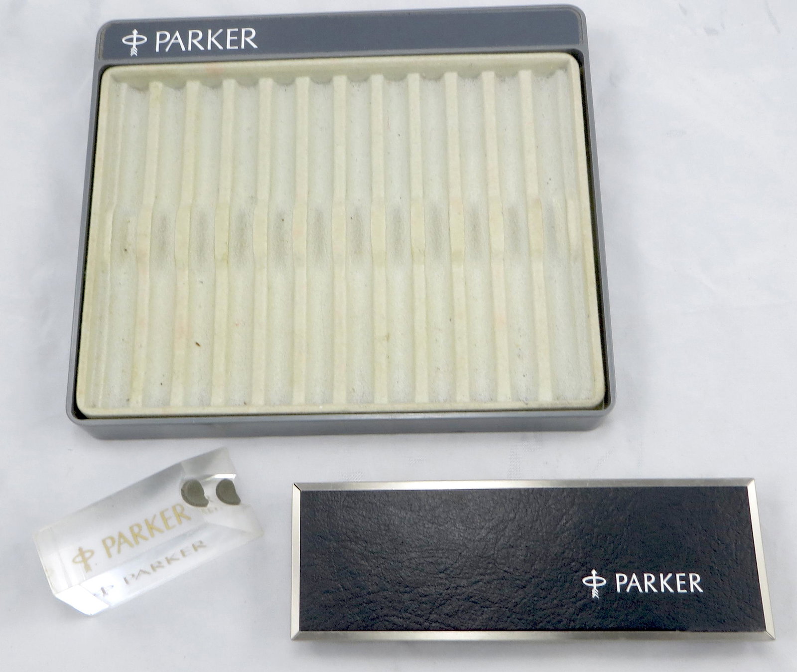 (3) PARKER ADVERTISING DISPLAYS & BOX: (1) 12-slot Parker pen tray, plastic; (1) plexi-glas pen display holder; (1) Parker Pen & Pencil set box, plush interior; longest L-8", G-VG