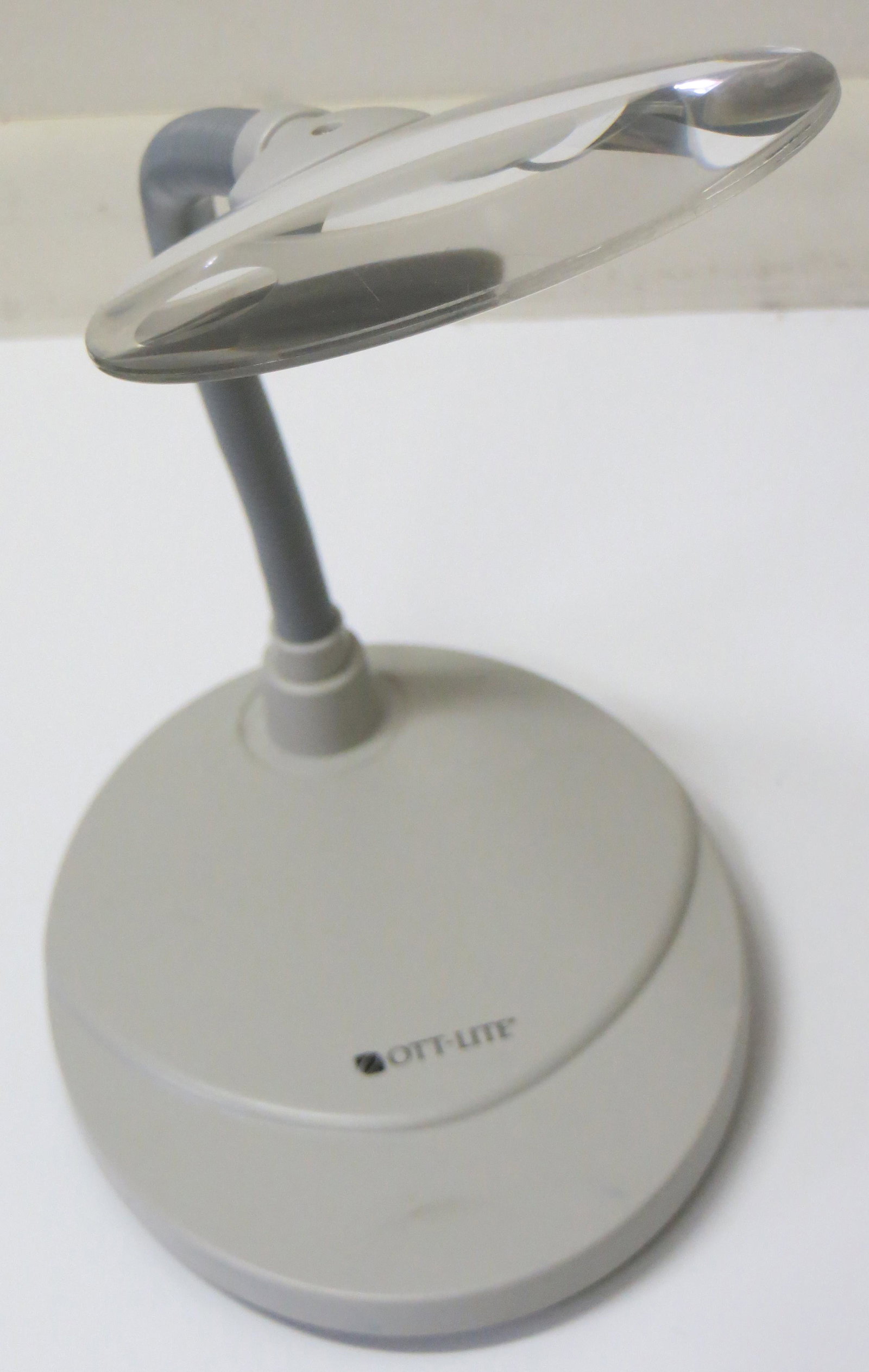 OTT-LITE OPTICAL GRADE MAGNIFIER: Weighted base, flexible arm; 5" diameter high resolution rimless lens; can be taken apart for shipping; bottom of base is cracked; (extended) L-22", F-G