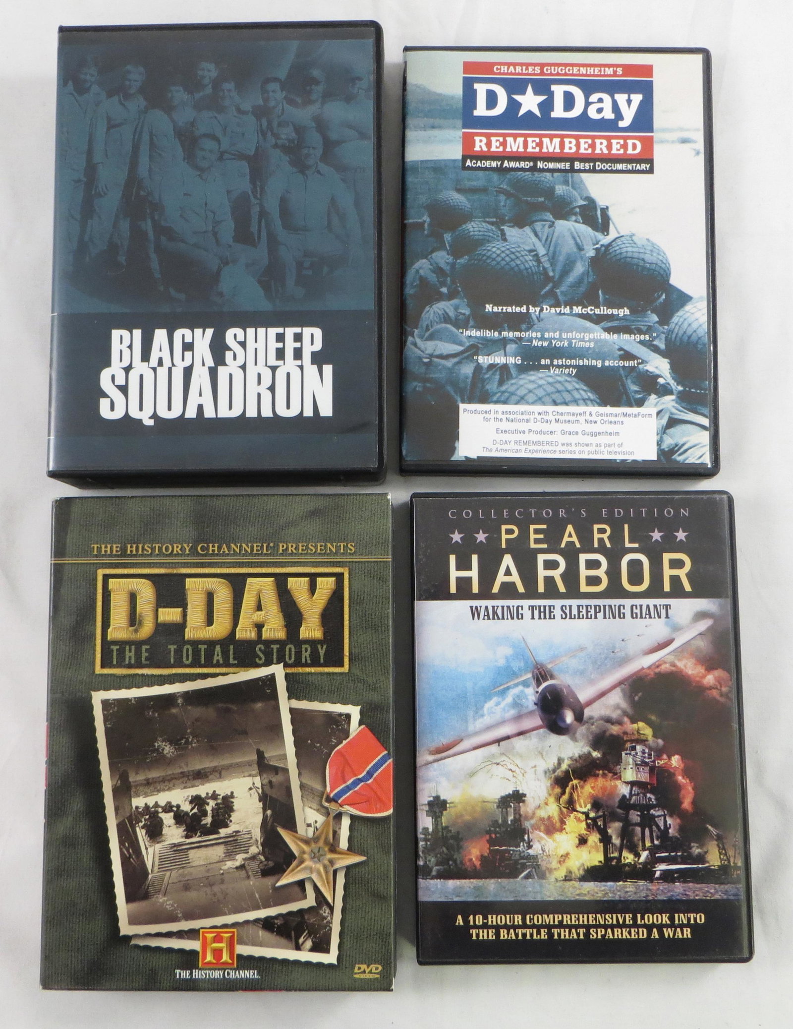(4) WWII DVD MOVIES: (2) vols. "D-Day the Total Story"; (2) Vols. "Pearl Harbor waking the sleeping Giant"; (13) vols. "Black Sheep Squadron"; (1) "D-Day Remembered"; 7 1/2" x 5 1/4", VG-EX