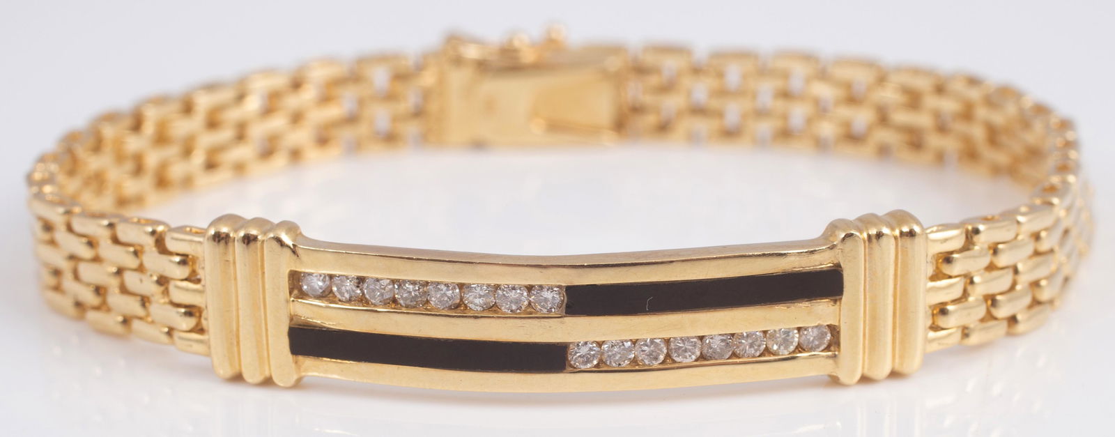 GOLD, DIAMOND & ONYX BRACELET: 14K yellow gold, Art Deco styling; curved bar with onyx band, (2) rows of (8) round brilliant diamonds, attached to a panera link bracelet, hidden box catch, figure eight safety; 23.1 grams total; 7 1