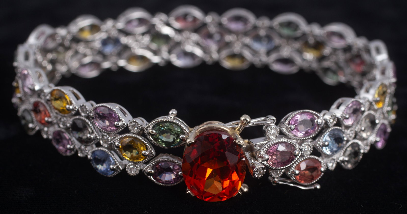 14K WHITE GOLD GEMSTONE BRACELET: Three rows of multi-colored semi-precious gemstones, interspaced with .01 carat diamonds; beaded settings; each oval faceted stone roughly 4mm x 6mm, in shades of pink, yellow, green, blue and red; cl