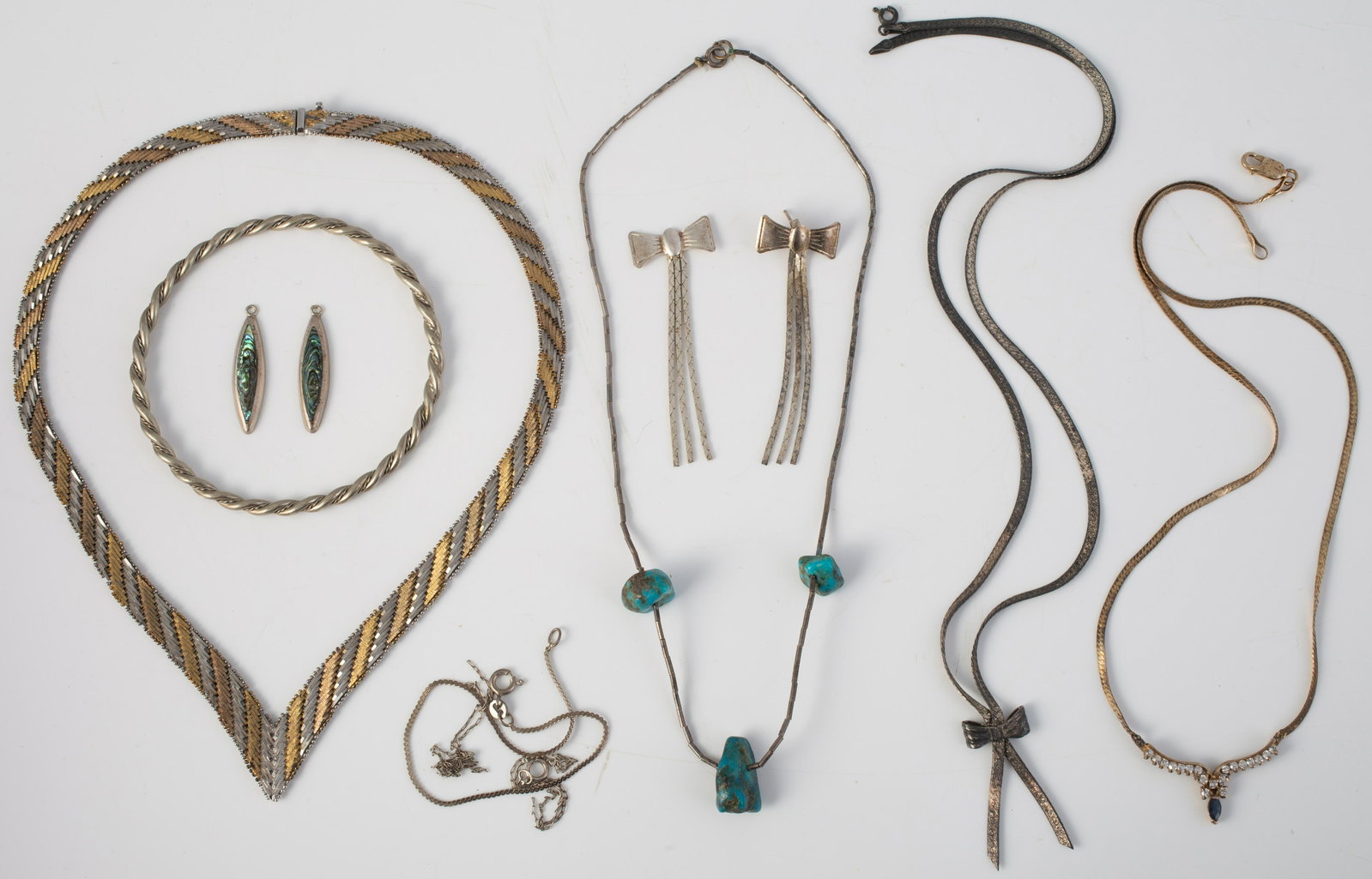 LOT OF ASSORTED SILVER & STERLING JEWELRY: Includes: (1) sterling serpentine bracelet; (1) sterling necklace with blue and clear stones; (1) sterling necklace with "bow" motif, with matching earrings (one broken); sterling 2-tone flat choker; 