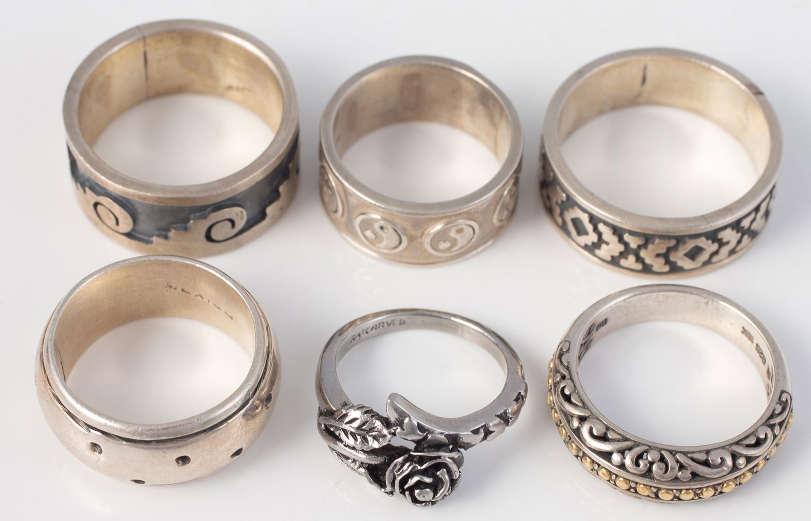 (6) STERLING BANDS: (1) rose band, size 4.5; (1) geometric band, size 10; (1) polka dot band, size 7; (1) beaded openwork band, size 7.5; (1) wave form band, size 8.5; (1) yin-yang band, size 6; 1.2 oz t total