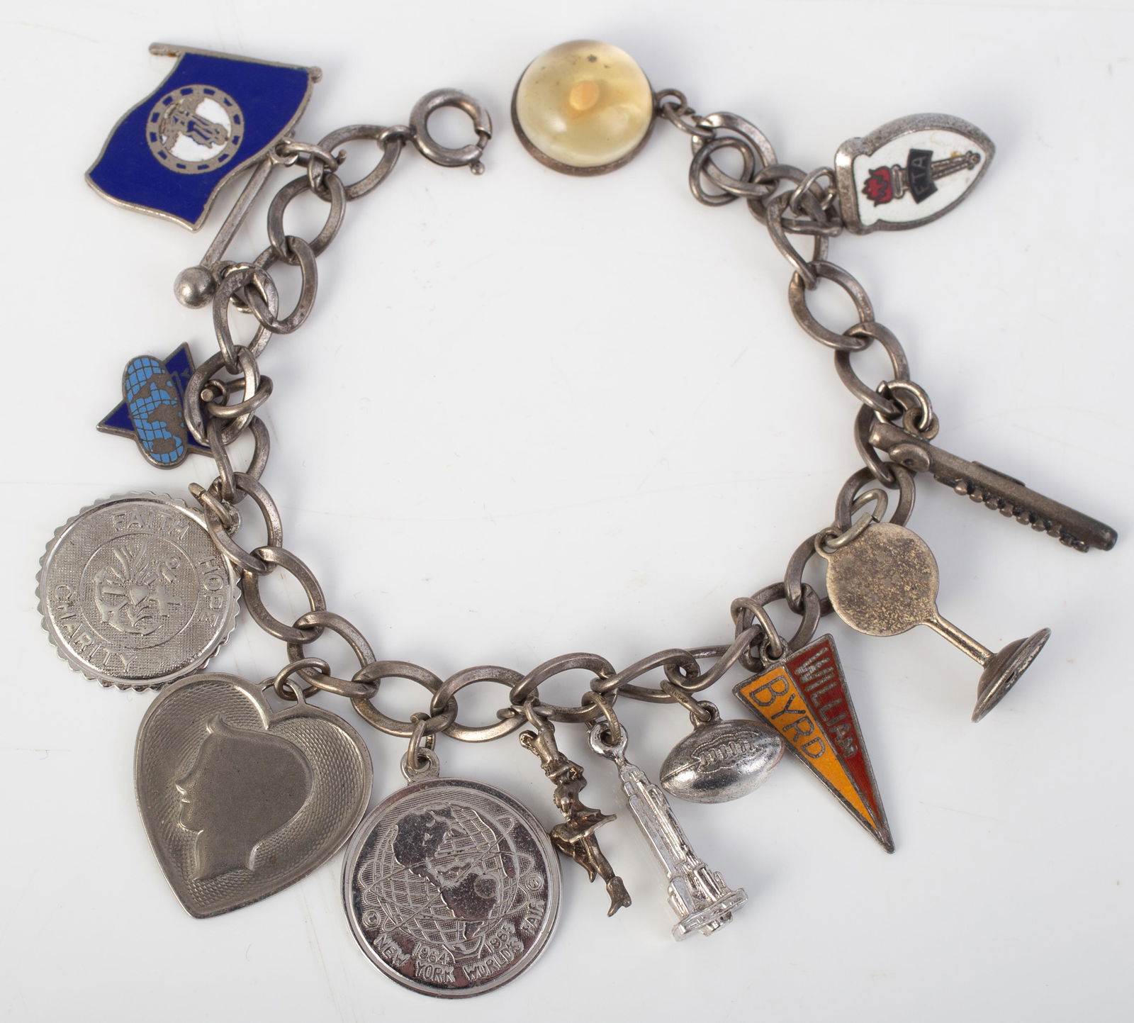 STERLING CHARM BRACELET: Charms include: marjorette, baton, '65 Worlds Fair, mustard seed, etc.; some charms with enamel, L-7", .99 oz t (total); VG