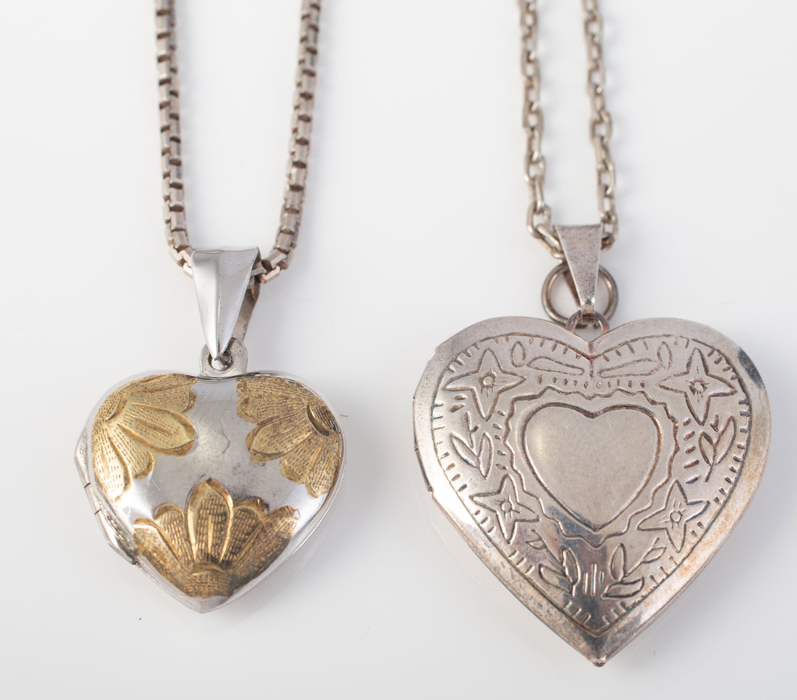 (2) STERLING HEART LOCKETS: (1) with box style chain, locket is two-tone, L-1 1/4" including bail; chain L-15"; (1) with link chain, heart L-1 1/2" including bail; chain L-22 1/4"; .67 oz t total, VG