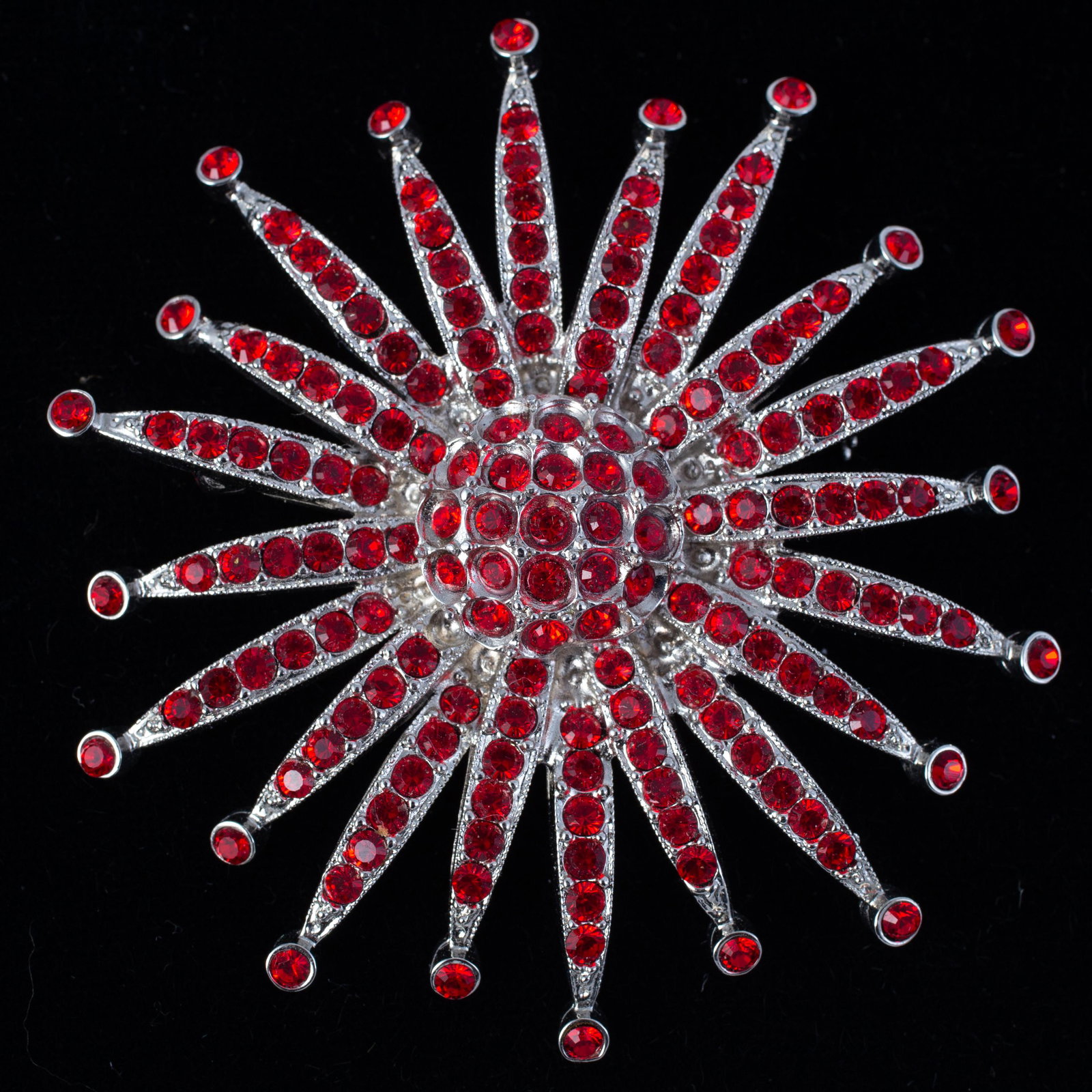ANN HAND STARBURST RHINESTONE PIN: silvertone, set with firey red rhinestones, signed on reverse, Dia.-2 1/2", EX