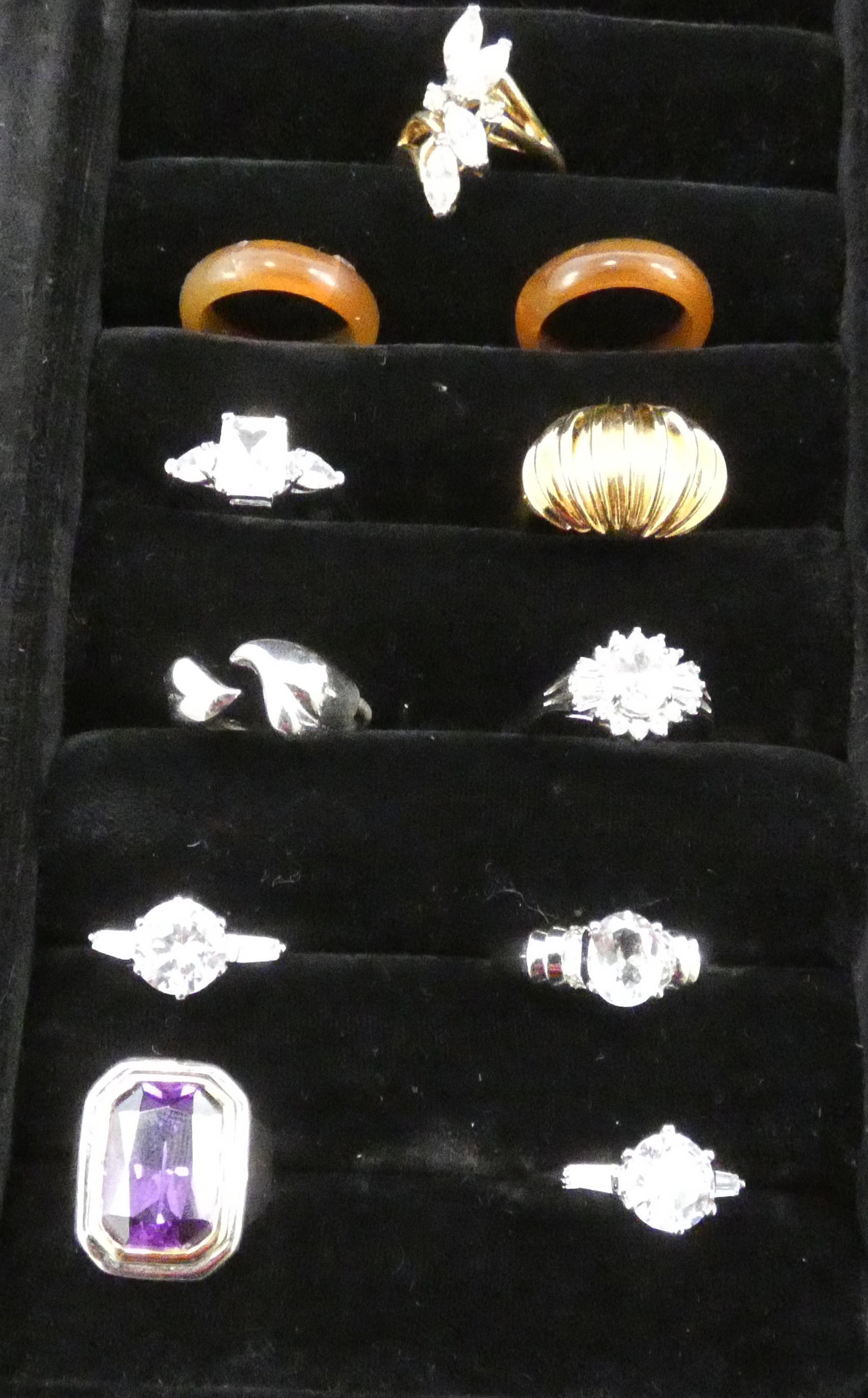 COSTUME JEWELRY RINGS (11): (5) silvertone with clear stones, (4) size 8.25, (1) size 9; (1) goldtone with clear stones, size 9; (1) large purple stone, size 6.5; (1) goldtone, size 7.25; (1) silvertone, size 8; (2) bakelite, si