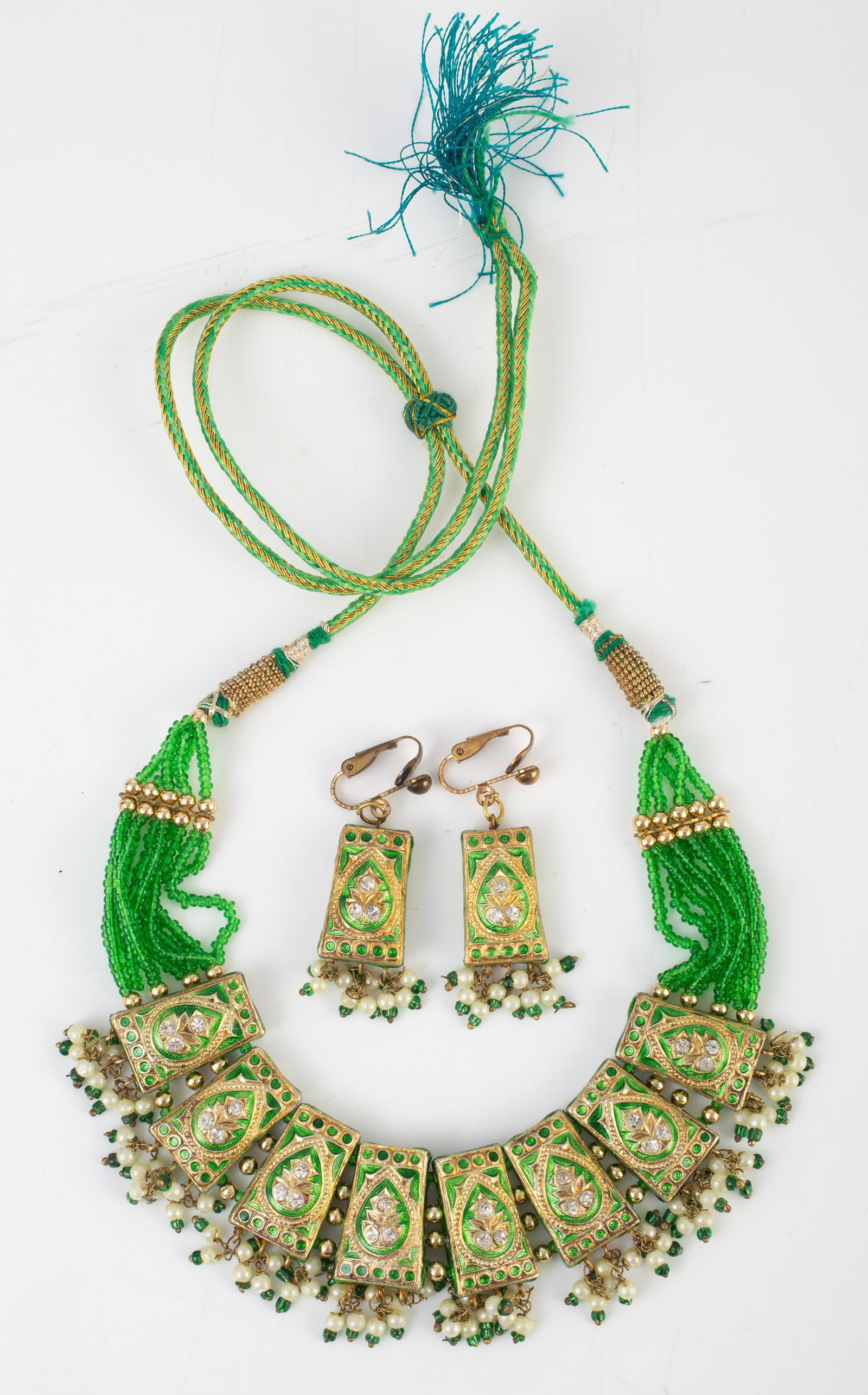MOGUL NECKLACE & EARRING SUITE: Green enamel, green seed beads, rhinestones and pearl beads; silk cord with slide adjustment, total L-14"; matching pair of clip style earrings, L-1 3/4"; EX