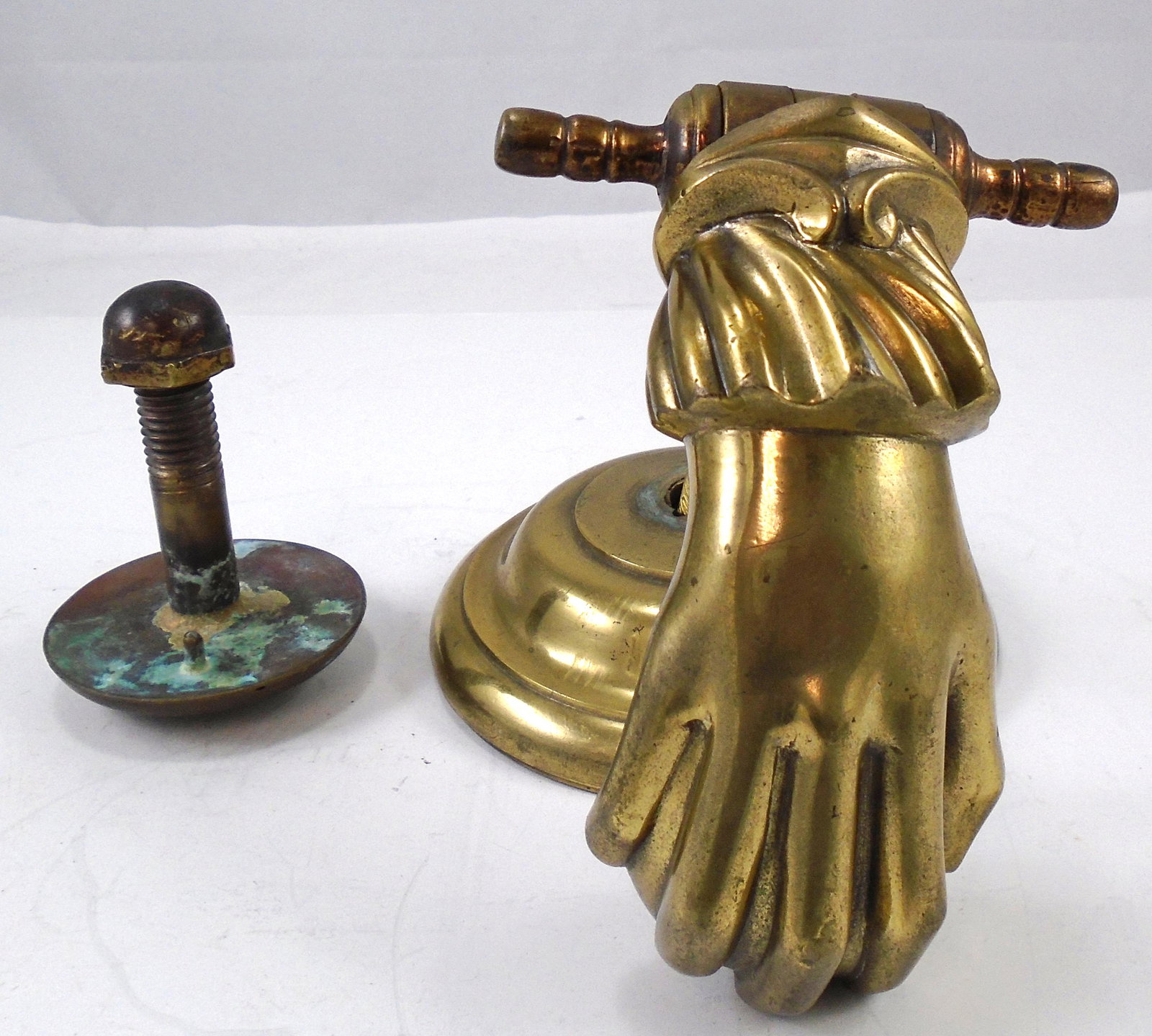 HEAVY BRASS (2) PIECE HAND DOOR KNOCKER: Round base plate with hand holding ball; heavy 3/4" dia. threaded mounting rod, together with a second round "striker" for the ball to hit; ; striking plate has dents from knocking; striker has age pa