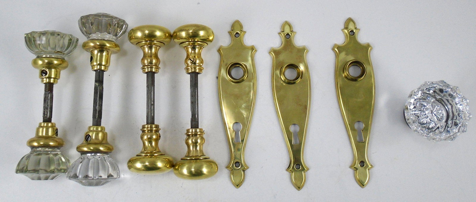 (8) PCS. VINTAGE DOOR HARDWARE: (2) pair door knobs: brass, complete with spindle; (1) set of door knobs, glass with flat central panel, with spindle, brass mounts; (1) set of glass door knobs, domed central panel, (1) knob has cent