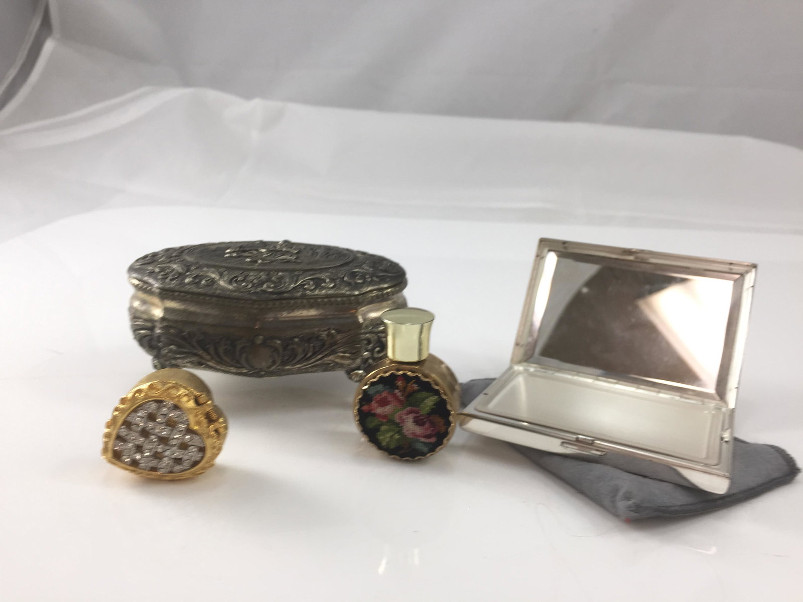 BOXES, COMPACT & PERFUME: (1) Silvertone footed box with red velvet lining; (1) goldtone and rhinestone pill box; (1) silvertone compact, made in Switzerland (appears unused); (1) perfume with pettipoint front; longest 4", VG-
