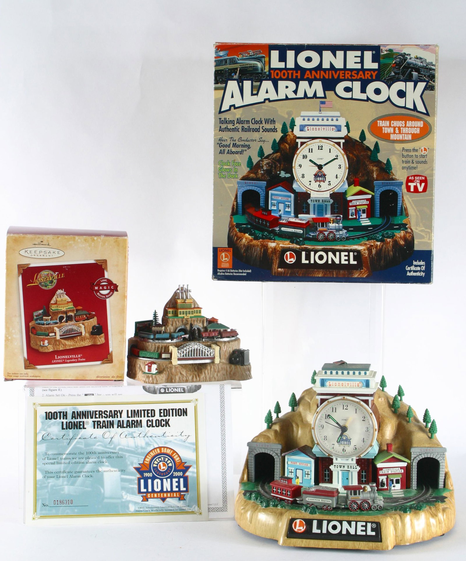 LIONELVILLE ALARM CLOCK & KEEPSAKE ORNAMENT: Original boxes; plastic and resin construction; (1) Lionel 100th Anniversary Alarm Clock, battery op, retains letter of authenticity, talks and glows in the dark; (1) Lionelville 2004 Hallmark Keepsak