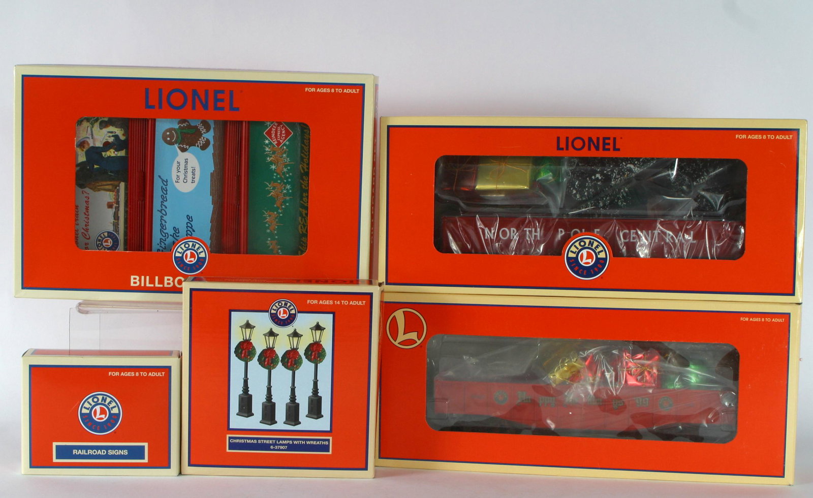 LIONEL CHRISTMAS RELATED CARS, SIGNS, LAMPS (5): All with original boxes; O Gauge; (1) Gondola with Holiday Load 6-26330; (1) Christmas Gondola 6-36032; (1) Christmas Billboard set 6-35295; (1) Christmas Railroad Signs 6-37185; (1) Christmas Street 
