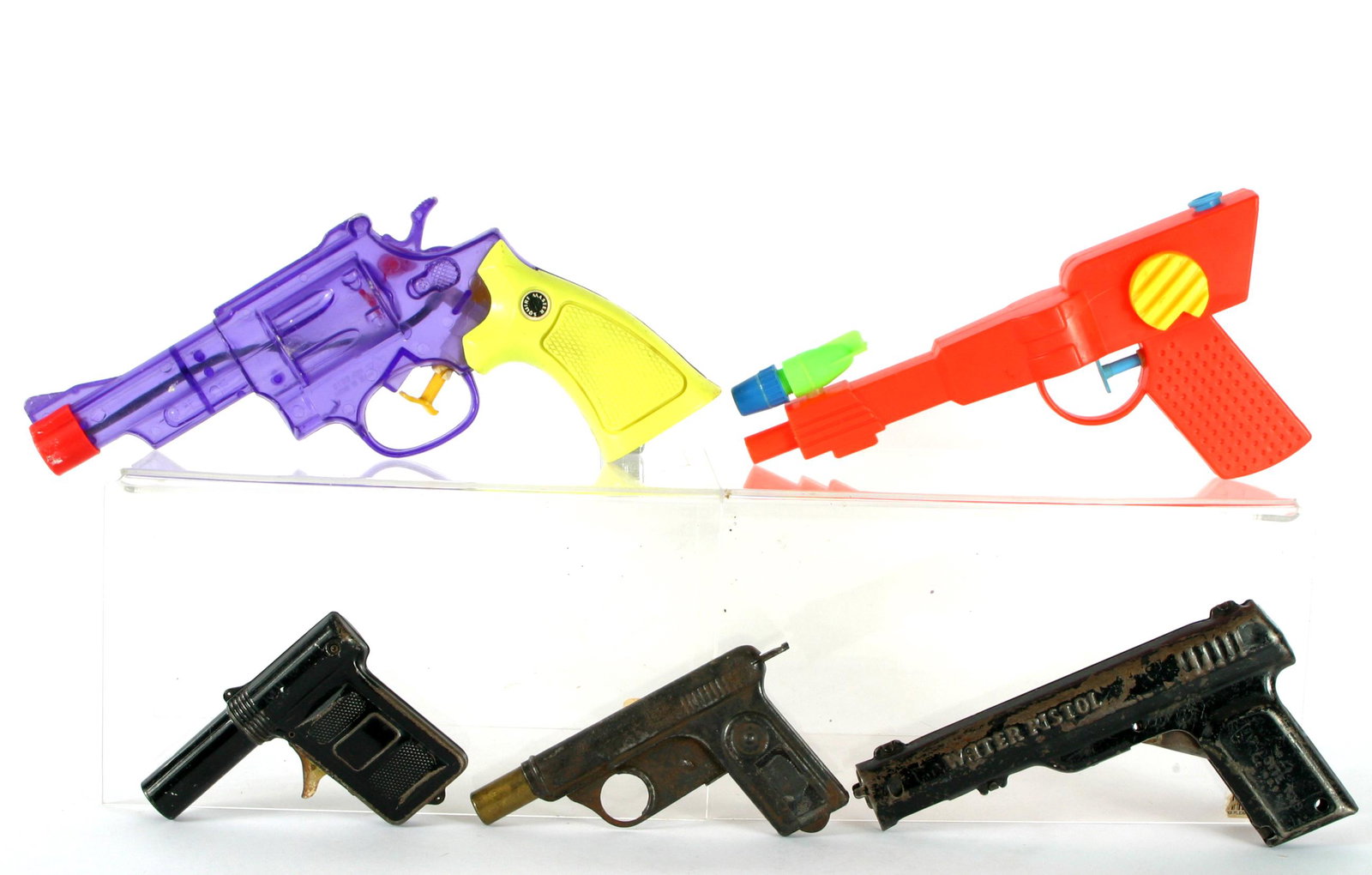 (5) PLASTIC & METAL WATER GUNS, ETC.: Includes: (1) antique water pistol No. 71, pressed metal, slide action works; L-5"; (1) antique black metal clicker gun; unknown manufacturer, pull trigger and "clicks", L-4"; (1) vintage Wyandotte bl