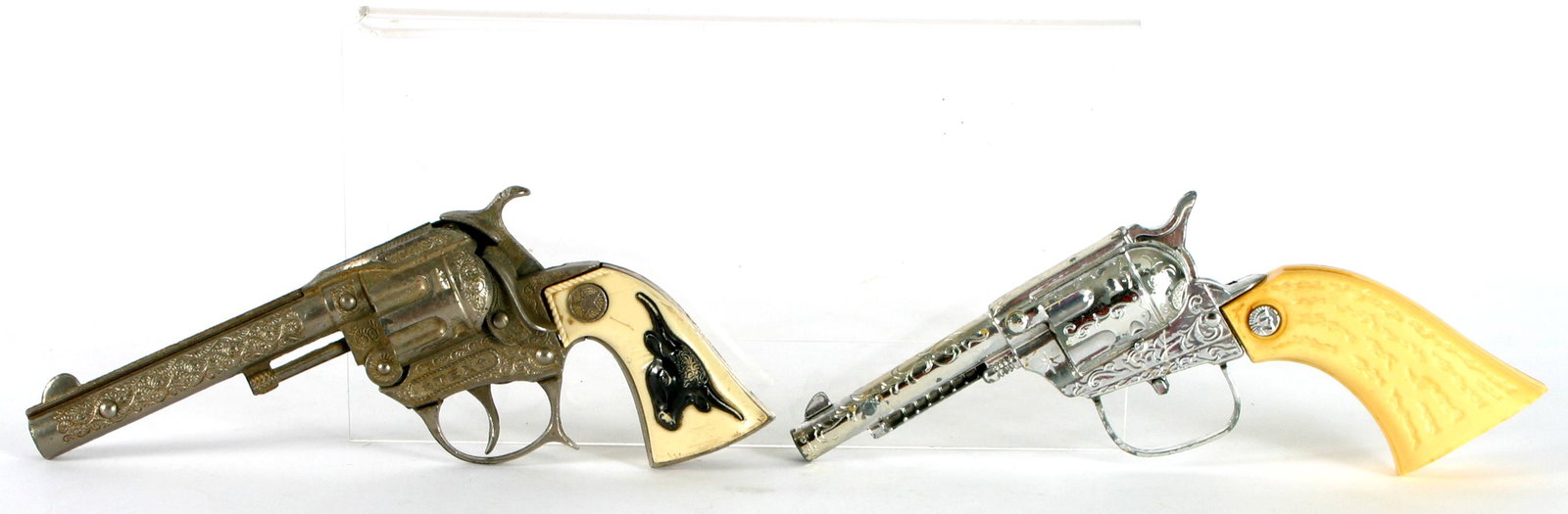 (2) VINTAGE CAP GUNS: HUBLEY TEX, ETC.: (1) Vintage Tex toy cap gun, Hubley; plastic black steer on white grips; L-8"; (1) unmarked cap pistol, white plastic grips, L-8";