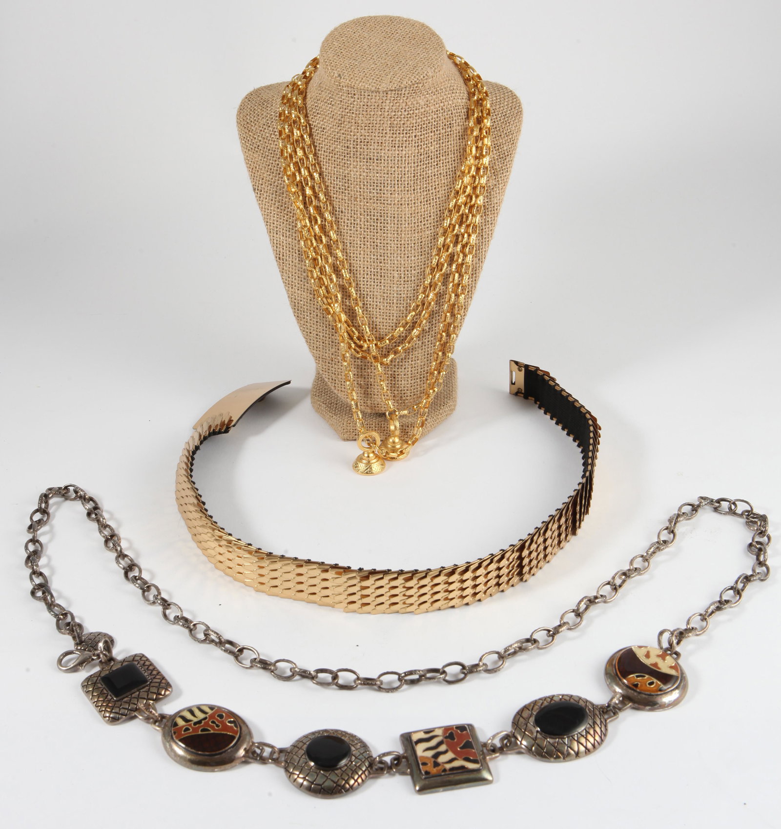 (3) METAL DRESS BELTS: (1) gold tone, scale type links with elastic backing; plain buckle; no tags; L-24"; (1) gold tone double strand chain, bell-shaped ends, no tags, L-48"; (1) Chicos belt, silver tone, six prominent ena