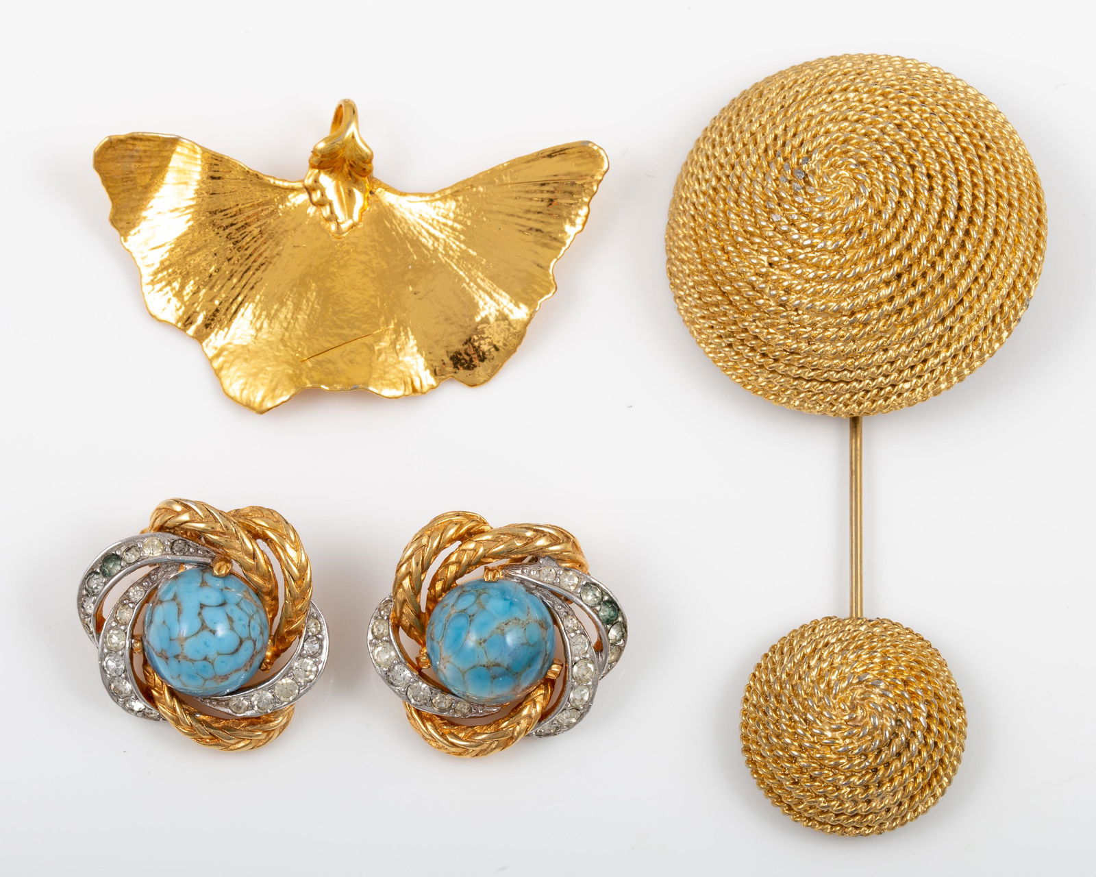 (3) PCS. GOLDTONE COSTUME JEWELRY - BOUCHER, ETC.: Includes: (1) gold tone gingko leaf pendant, unsigned; (1) gold tone two part pin, coil motif, (1) pair Boucher clip earrings, gold and silver tone with clear stones and high domed cabochon stones, so