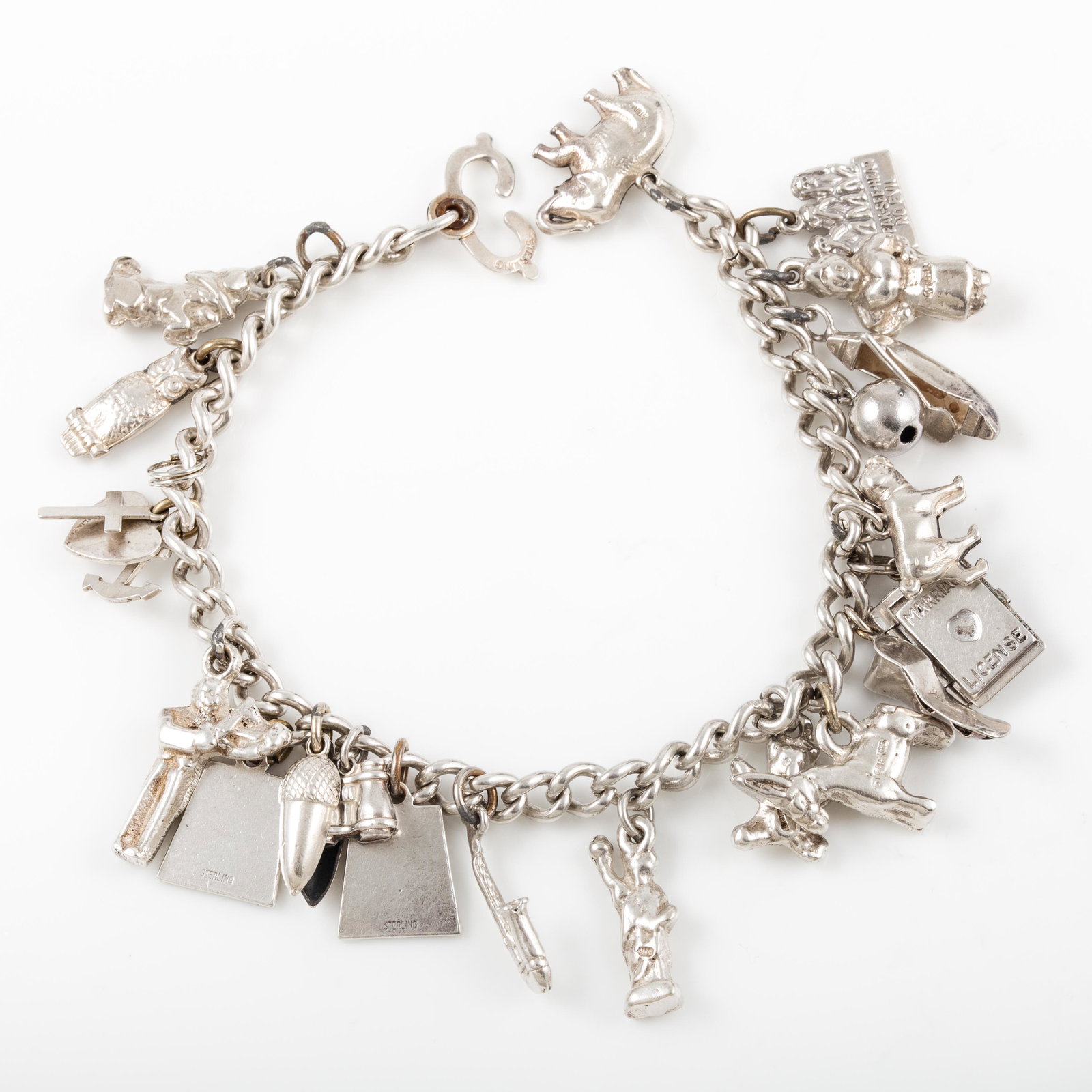 STERLING CHARM BRACELET: (20) Charms, including: elephant, dog, three monkeys, owl, acorn, binoculars, "April", saxophone, donkey, shoe, etc.; [1.59 ozt total], L-7 1/4", VG-EX