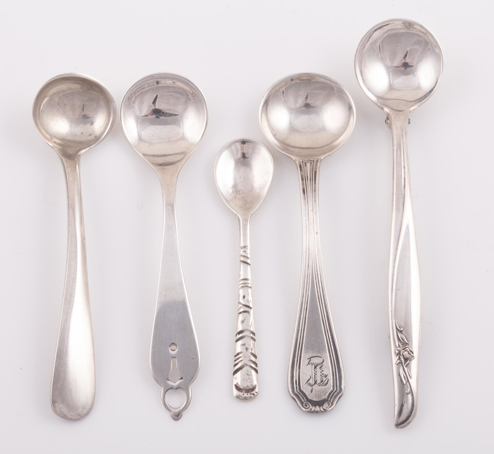 (5) STERLING SALT SPOONS: (1) Salt spoon, horse hallmark, marked sterling, scroll border on handle, indistinct monogram, L-2 1/3", .11 ozt; (1) salt spoon, handle with engraved lines, marked .85, L-1 3/4", .05 ozt; (1) S. Kirk