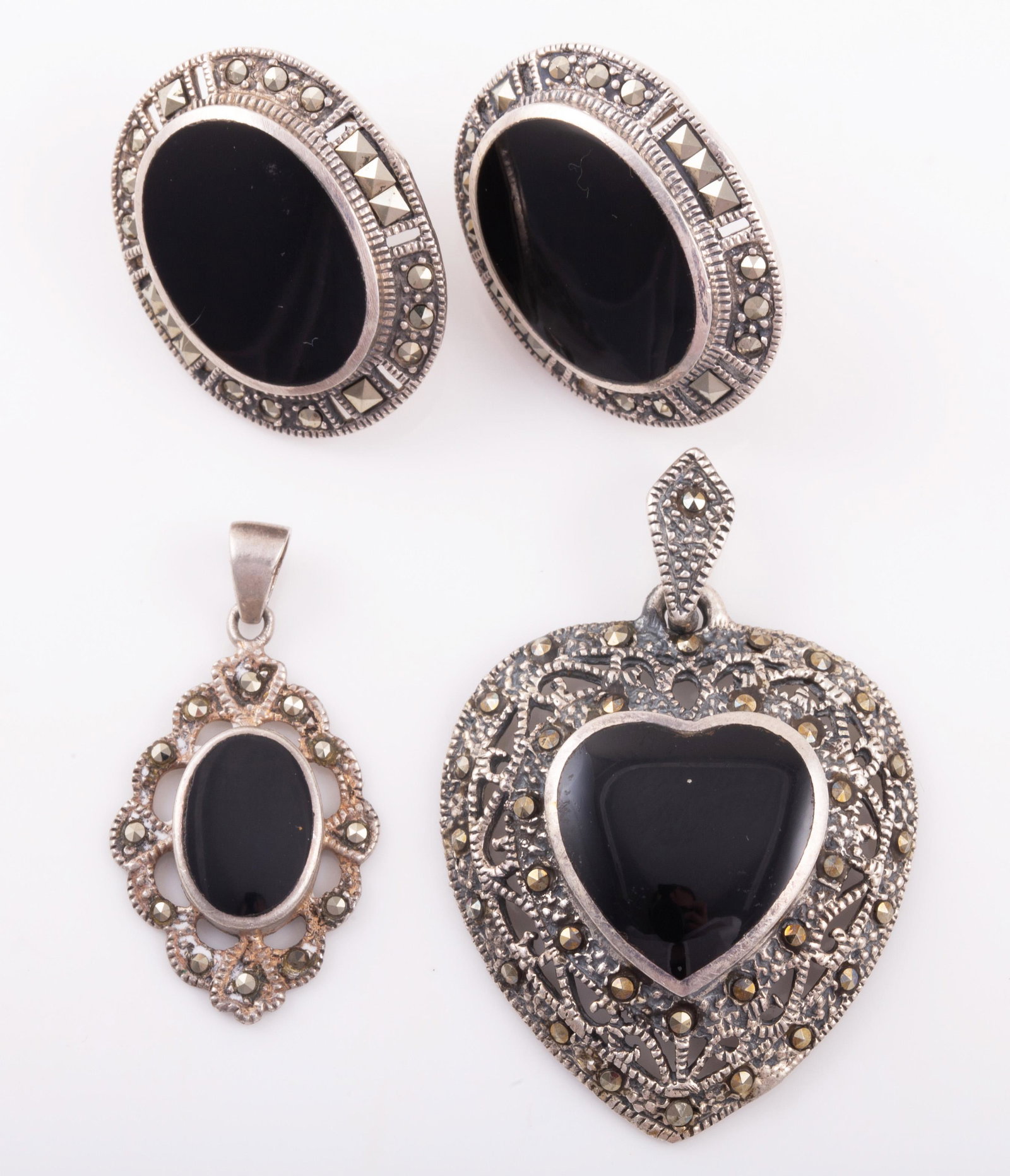 STERLING, MARCASITE & ONYX PENDANTS & EARRINGS: Includes: (1) sterling marcasite pendant with onyx heart-shaped cabochon stone, stone 16 mm x 16mm, approx. L-1 3/4", .22 ozt total; (1) sterling marcasite & onyx pendant, oval onyx stone 12 mm x 8 mm