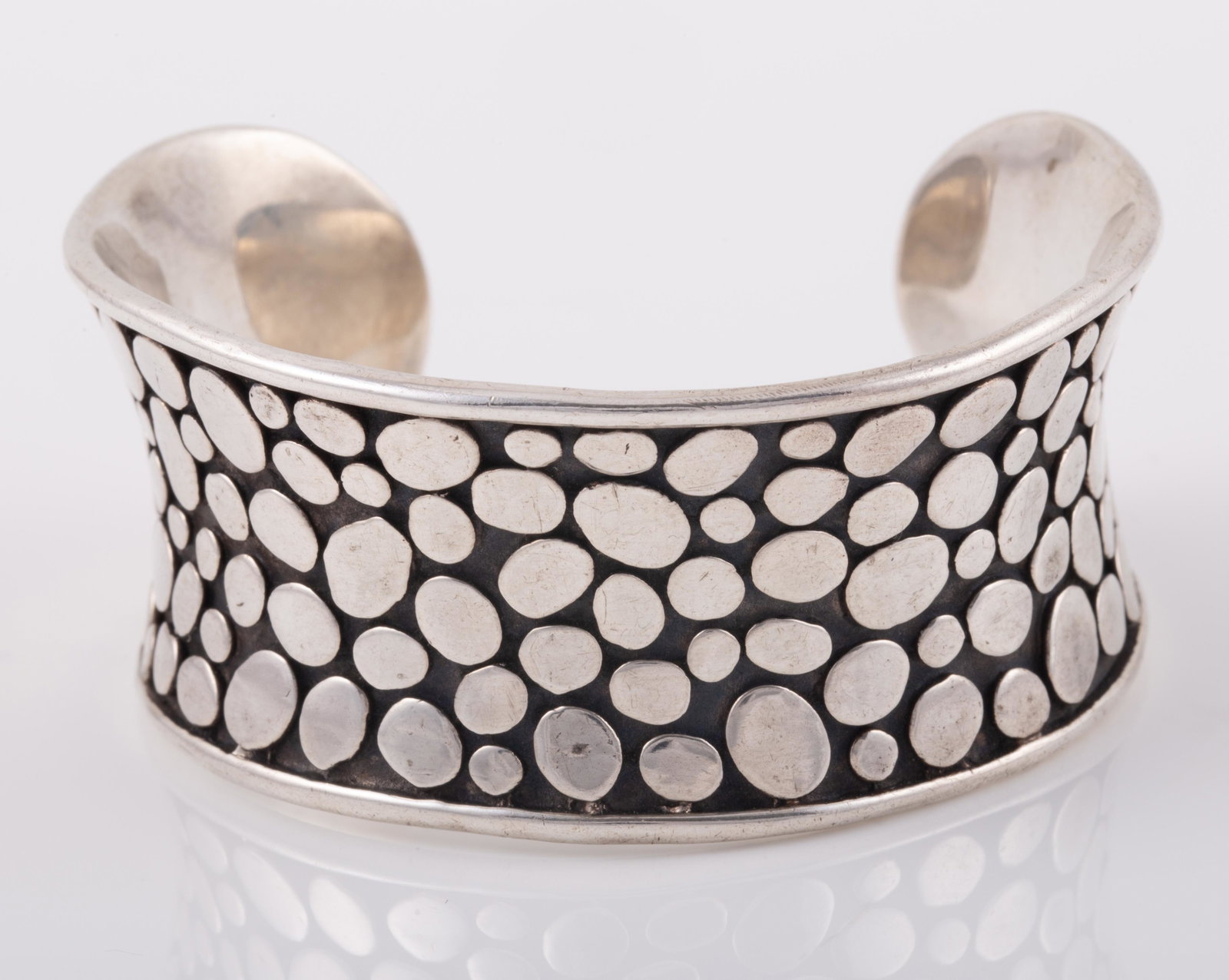 STERLING PEBBLE CUFF JGD JANICE GIRARDI: Sterling cuff bracelet, pebble motif, signed JDG on interior, interior L-2 1/4" but somewhat flexible, width approx. 1", total length 5 3/4", [1.62 ozt]; EX