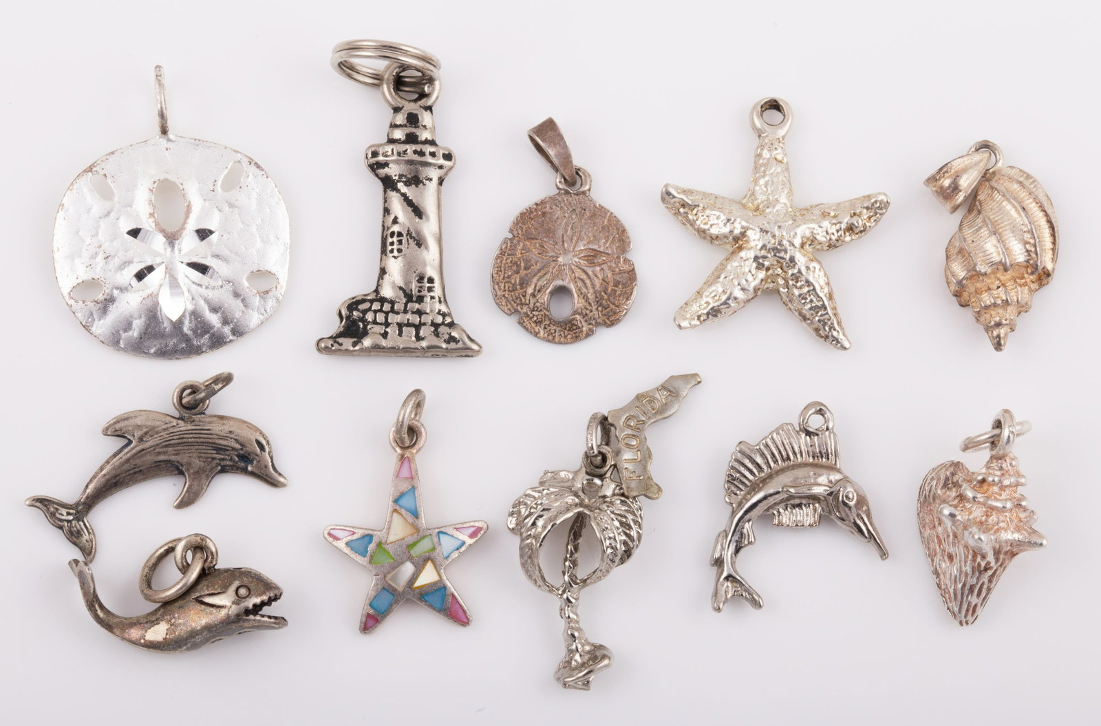 (11) STERLING BEACH THEMED CHARMS: Sand dollars, sea shells, star fish, whale, dolphin, fish, light house & palm tree; .54 ozt, L - 1", (2) missing jump rings G -VG