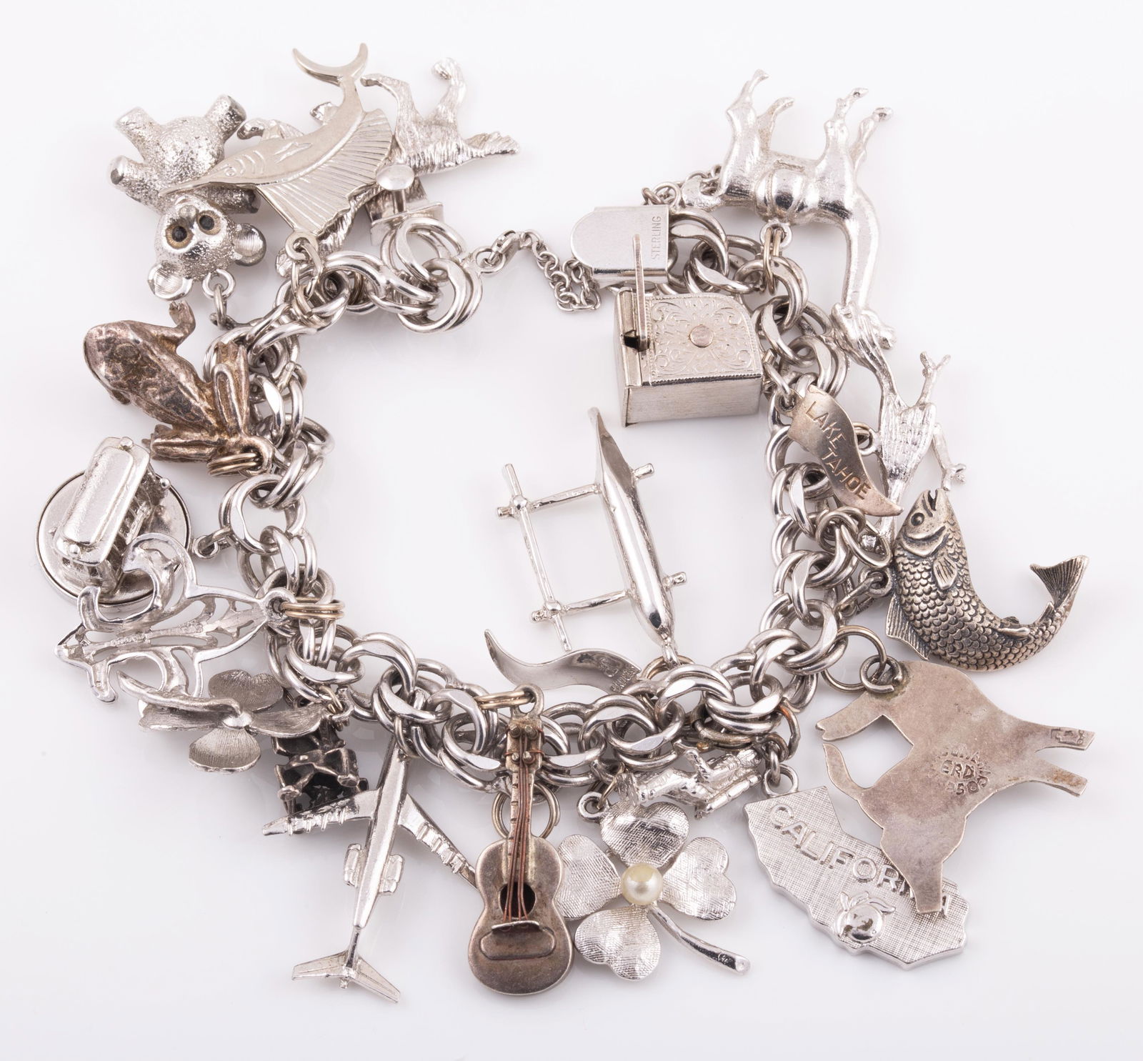 STERLING CHARM BRACELET: 19 Charms: Airplane, Animals, Slot Machine, Dogwood Flower, Guitar, Frog, Fish, Clover etc.; 2.59 ozt L - 8 1/2" G - VG